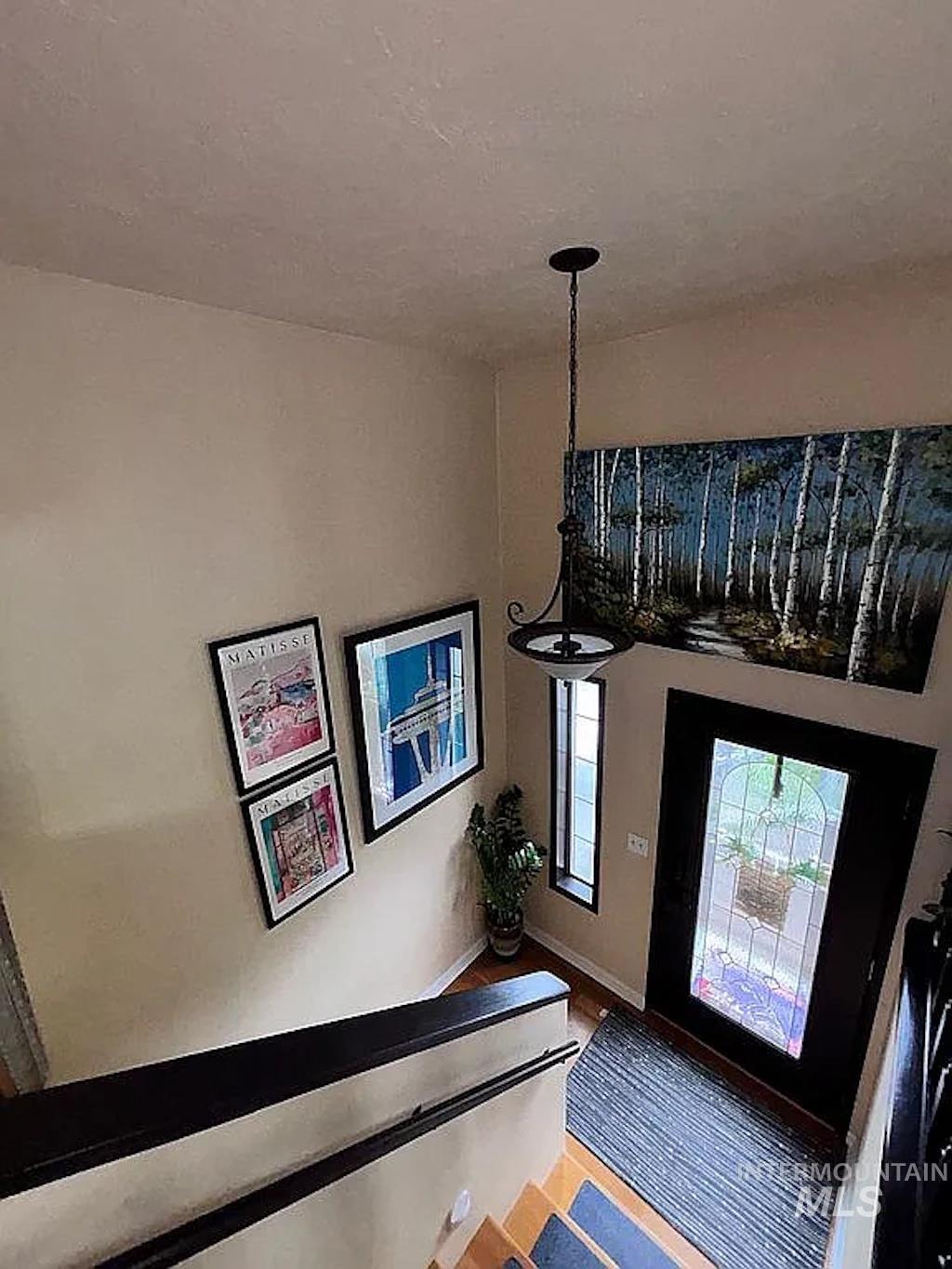 Entryway featuring a dark wood door with decorative glass, side window, and wood-finish flooring