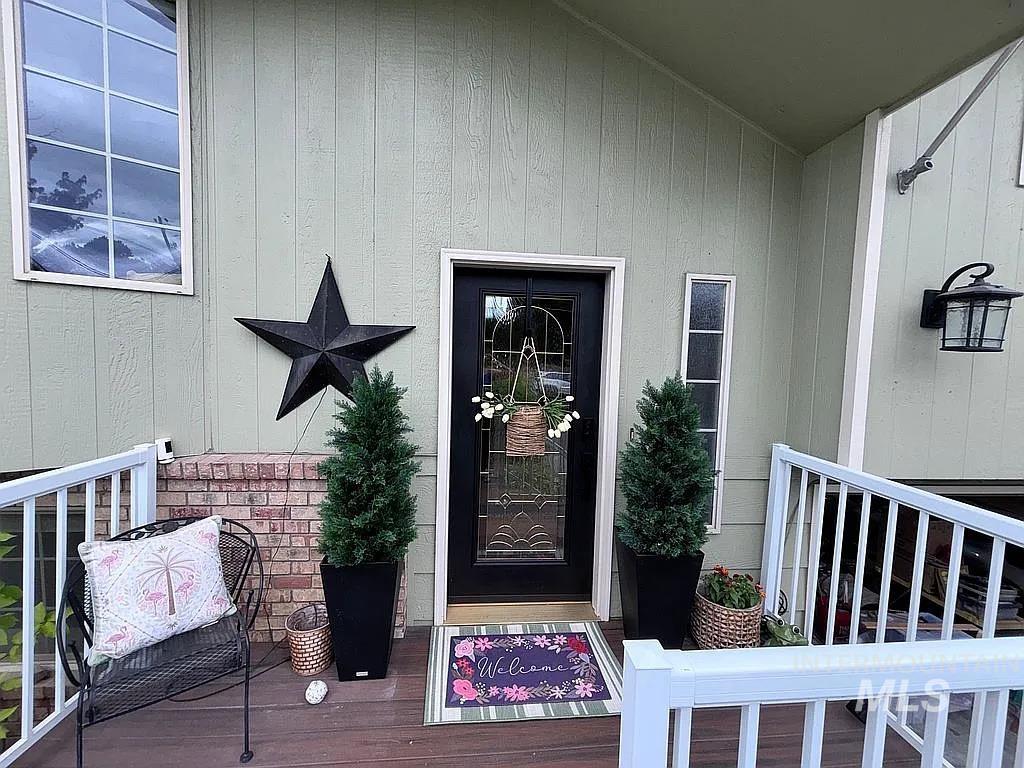 Front entry featuring a black door with decorative glass, two vertical sidelight windows, and a black exterior light fixture