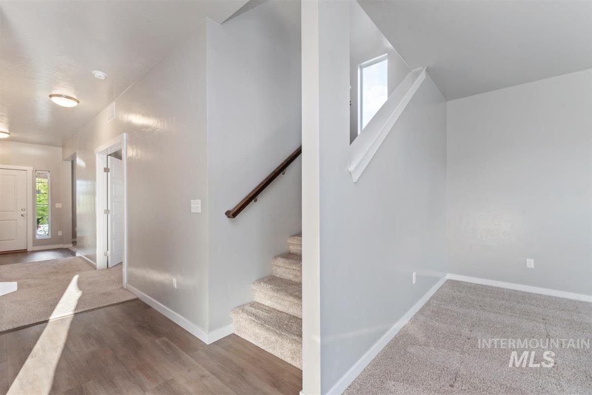 Entryway with healthy amount of natural light, stairs, and wood finished floors