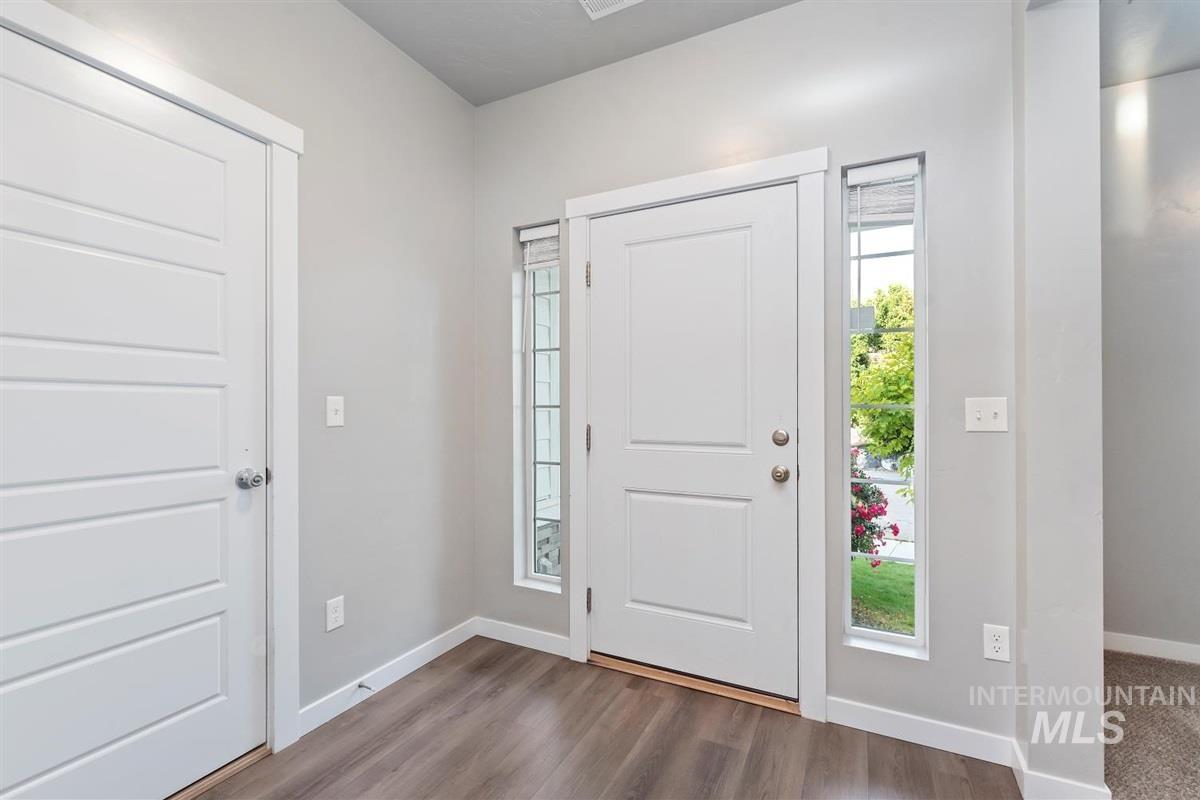 Entryway with baseboards and wood finished floors