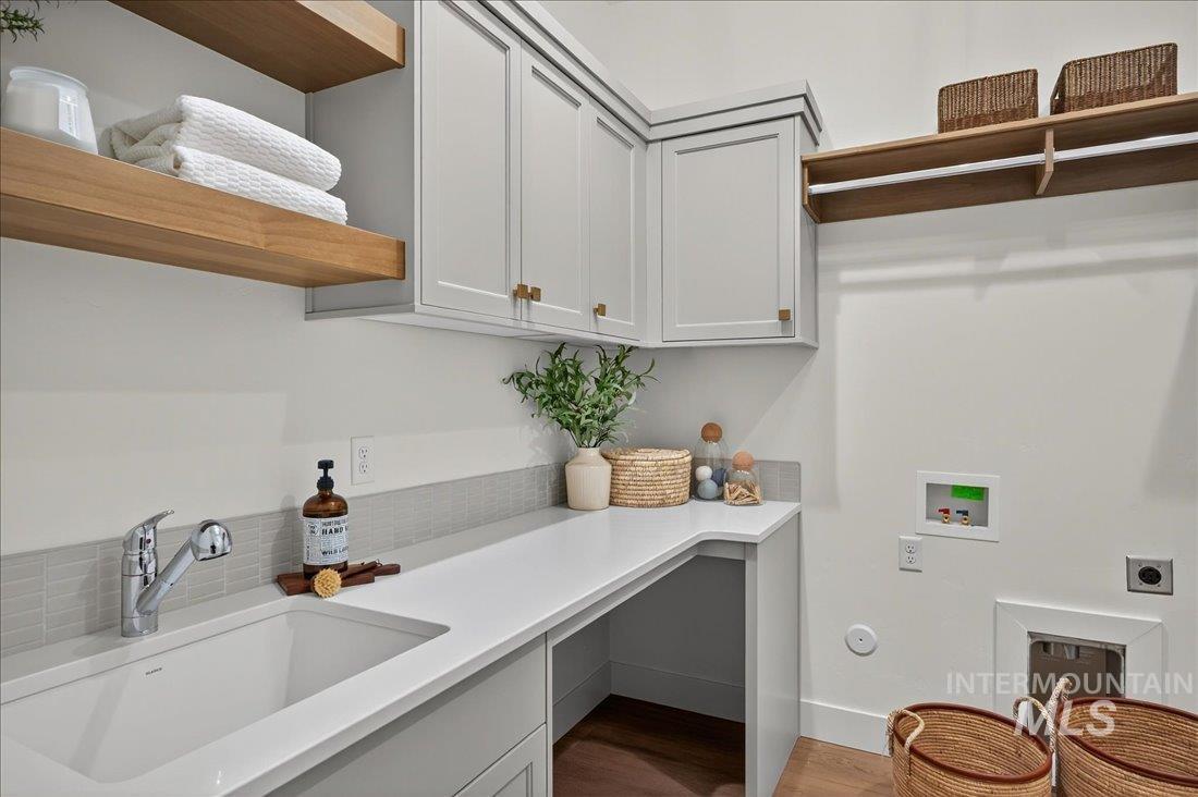 Laundry room featuring washer hookup, dark wood-style floors, electric dryer hookup, and cabinet space