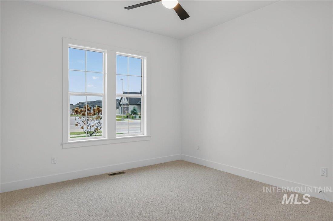Unfurnished room featuring light colored carpet and a ceiling fan