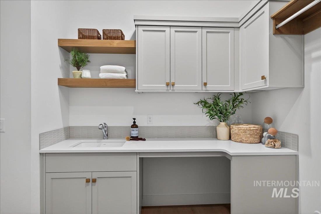 Bar area featuring open shelves and light stone counters