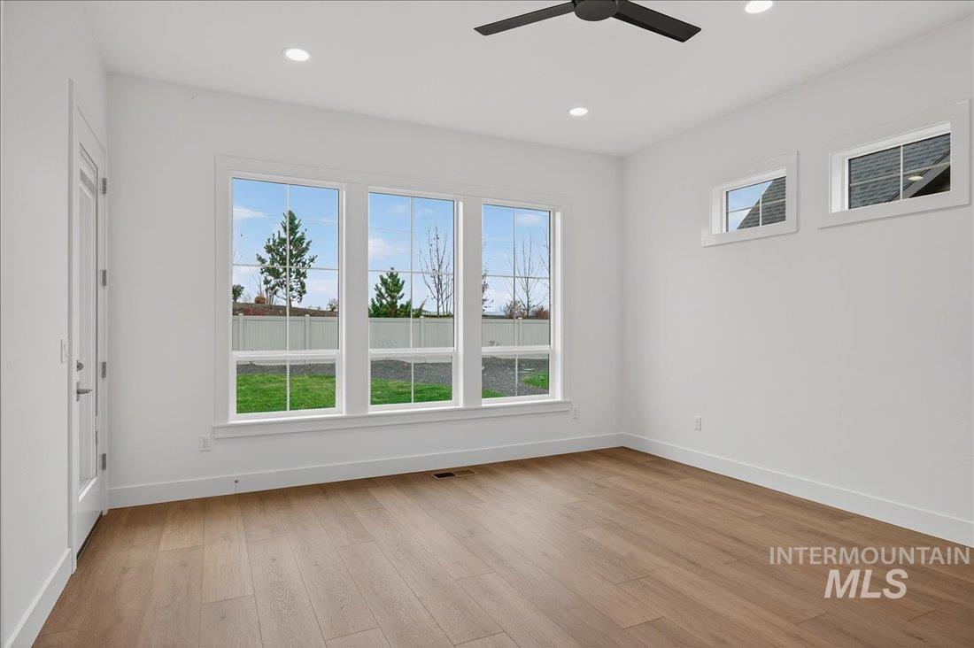 Spare room featuring light wood-type flooring, healthy amount of natural light, recessed lighting, and a ceiling fan