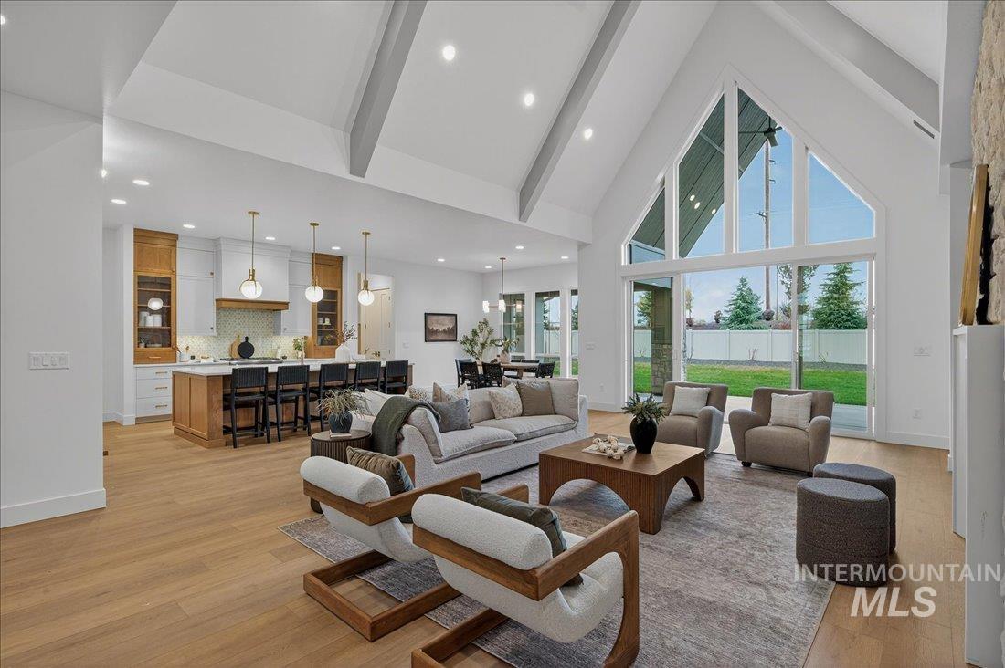 Living area with high vaulted ceiling, beamed ceiling, light wood finished floors, and recessed lighting