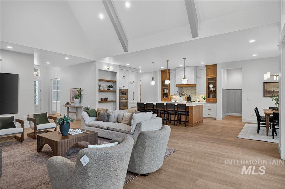 Living area with beam ceiling, high vaulted ceiling, light wood-type flooring, and recessed lighting