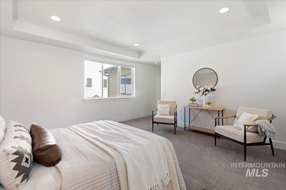 Carpeted bedroom featuring a tray ceiling, recessed lighting, and crown molding