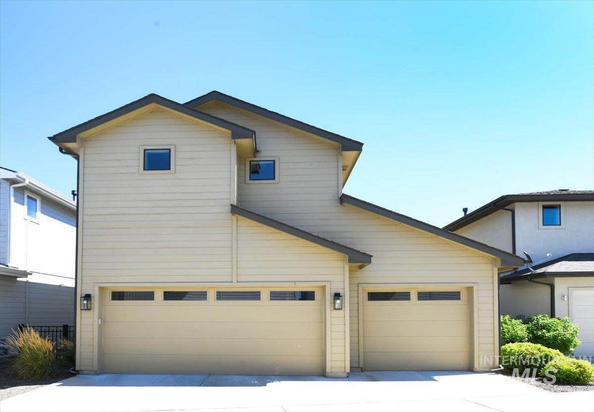 View of front of property with concrete driveway and a garage