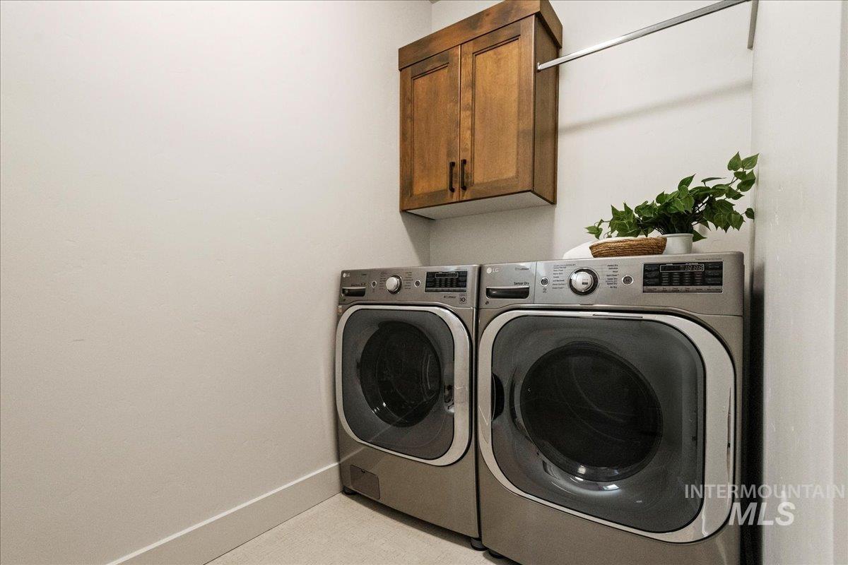 Washroom featuring separate washer and dryer and cabinet space