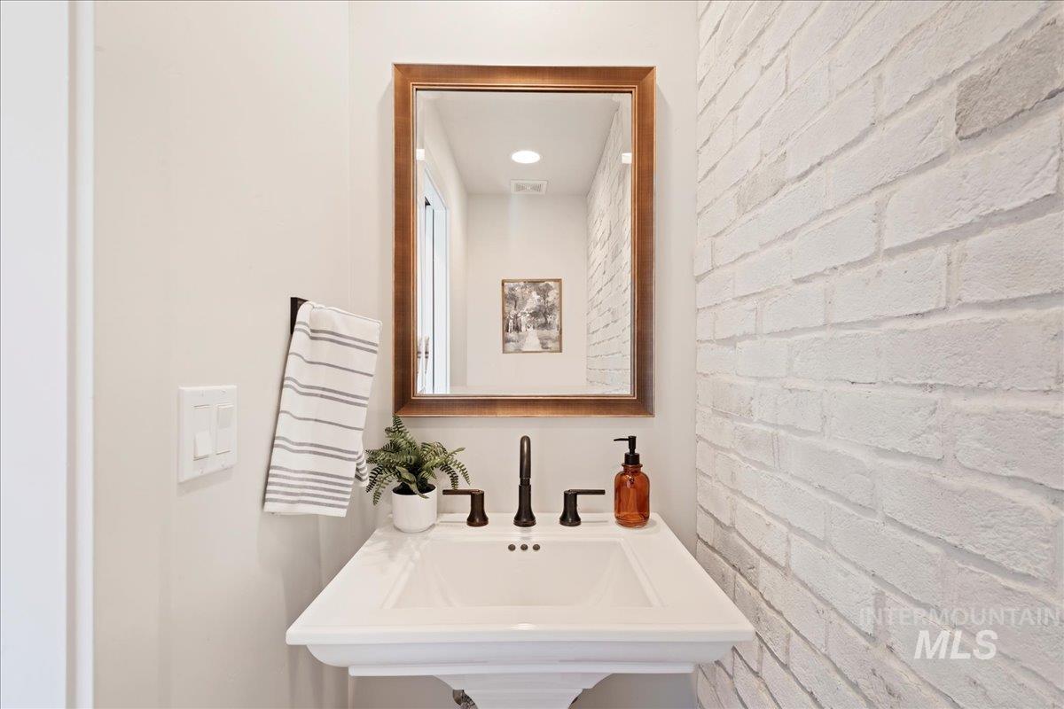 Bathroom featuring recessed lighting and brick wall