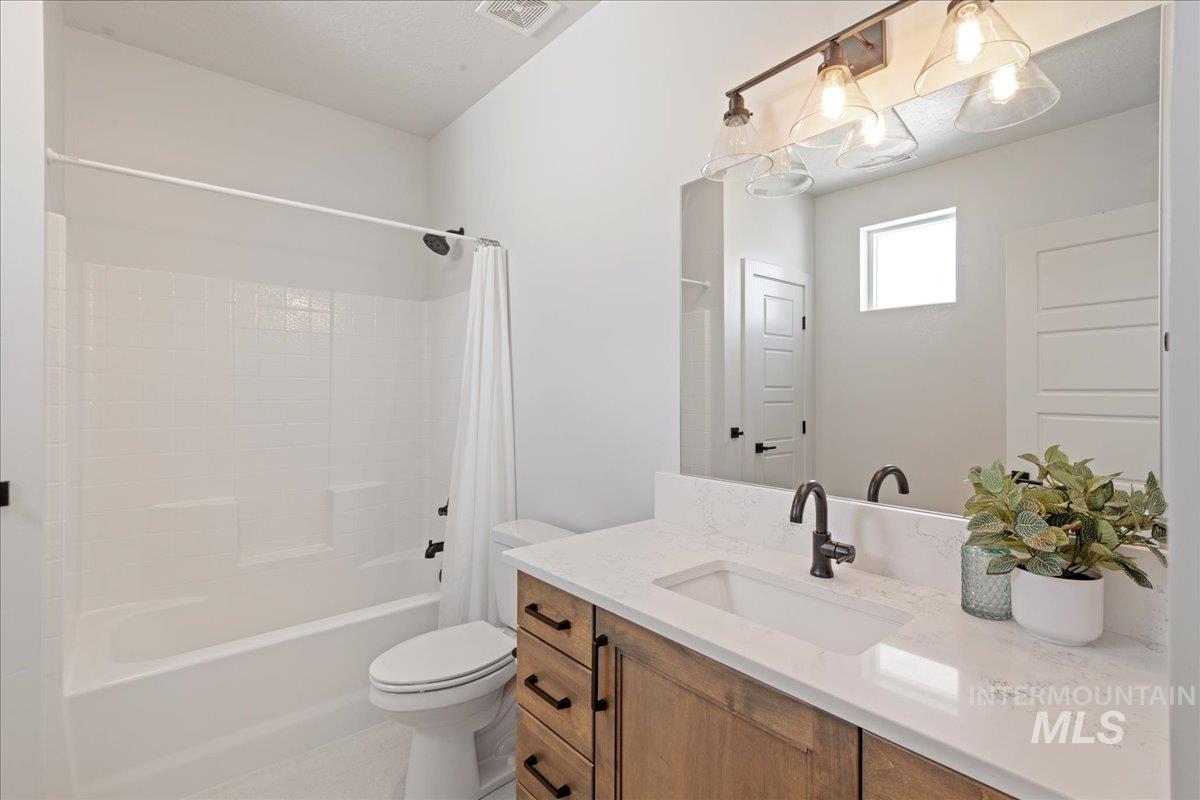 Full bathroom featuring shower / bathtub combination with curtain and vanity