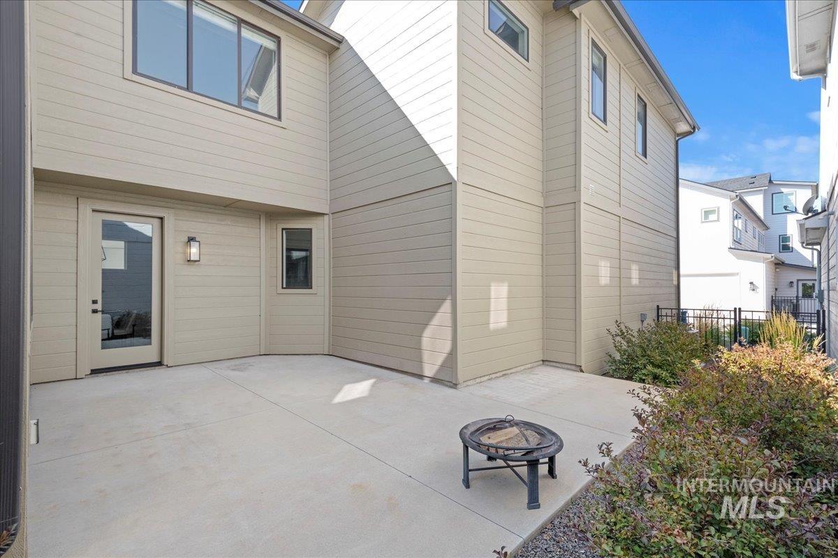 Rear view of house featuring an outdoor fire pit and a patio area
