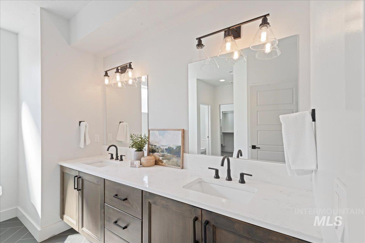 Bathroom with double vanity and baseboards