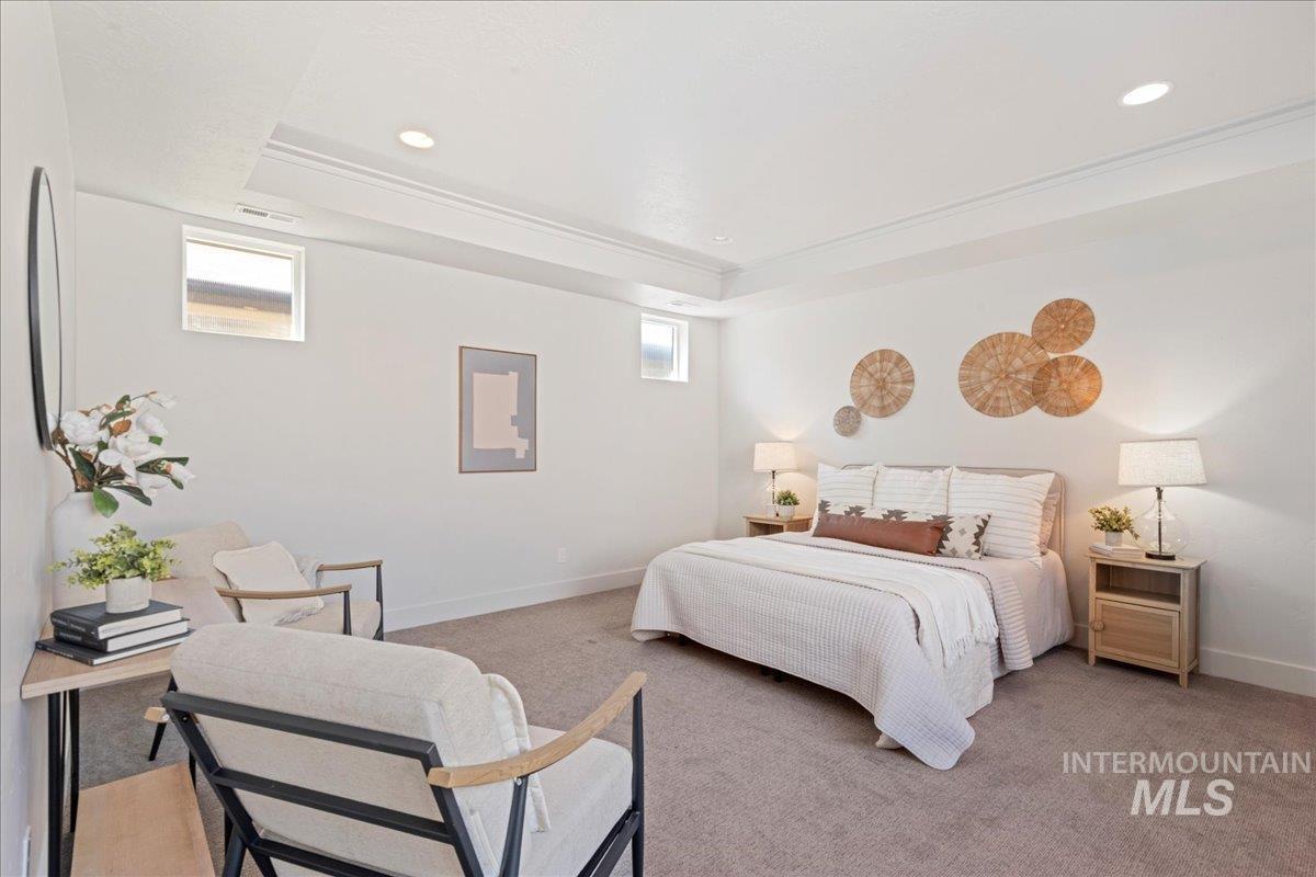 Carpeted bedroom featuring a tray ceiling and recessed lighting