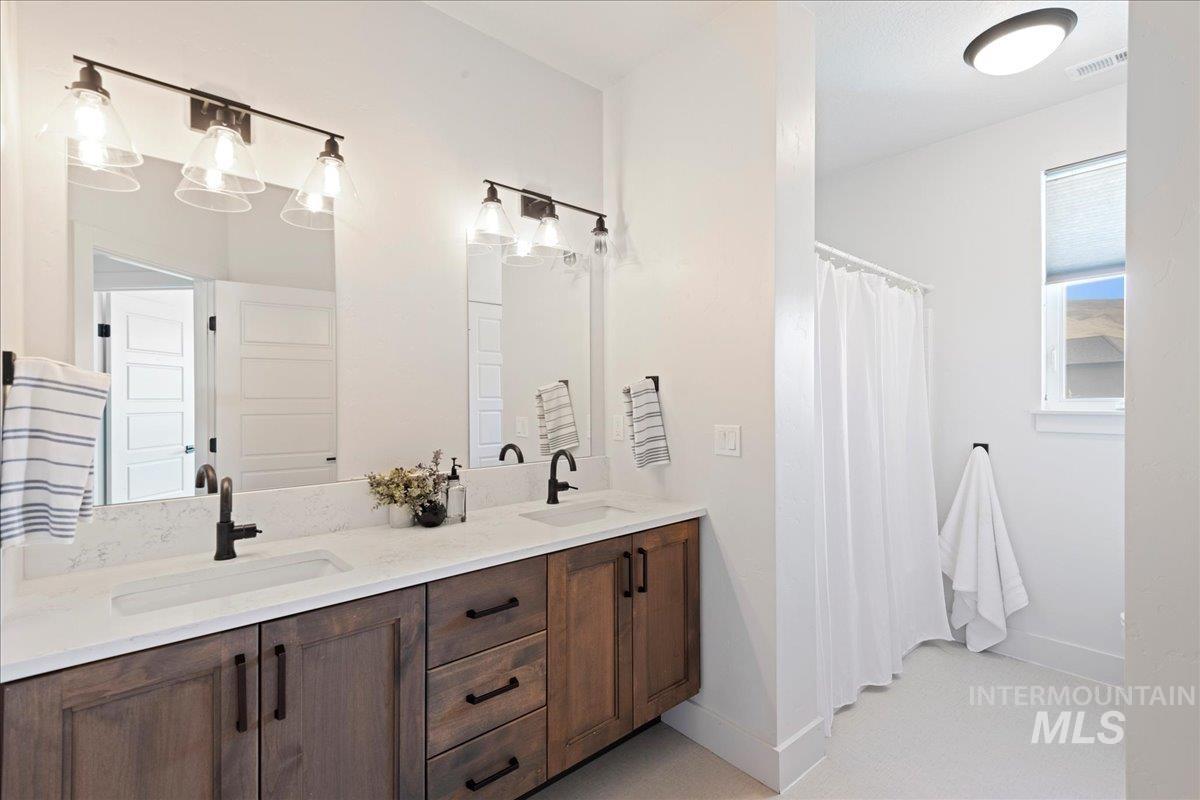 Bathroom featuring double vanity and a shower with curtain