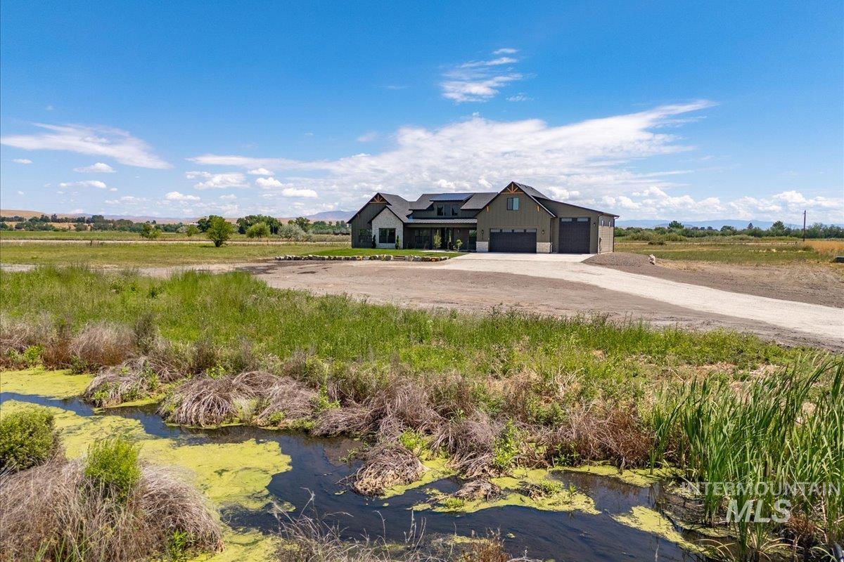 Modern farmhouse with driveway, an attached garage, and roof mounted solar panels