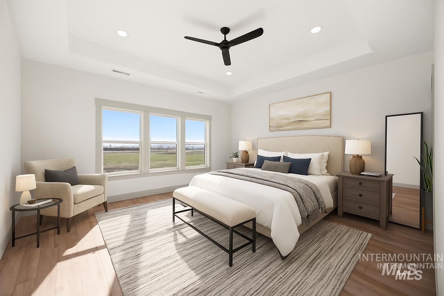 Bedroom with a raised ceiling, wood finished floors, recessed lighting, and a ceiling fan