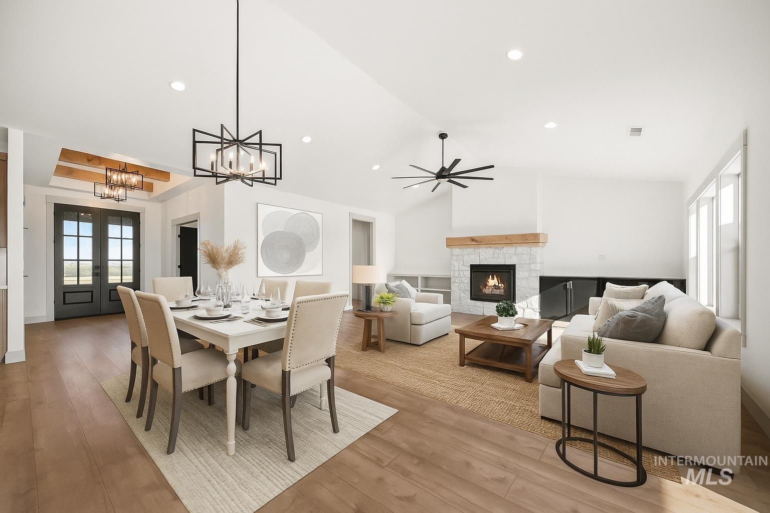 Dining area featuring a chandelier, a fireplace, vaulted ceiling, light wood finished floors, and recessed lighting
