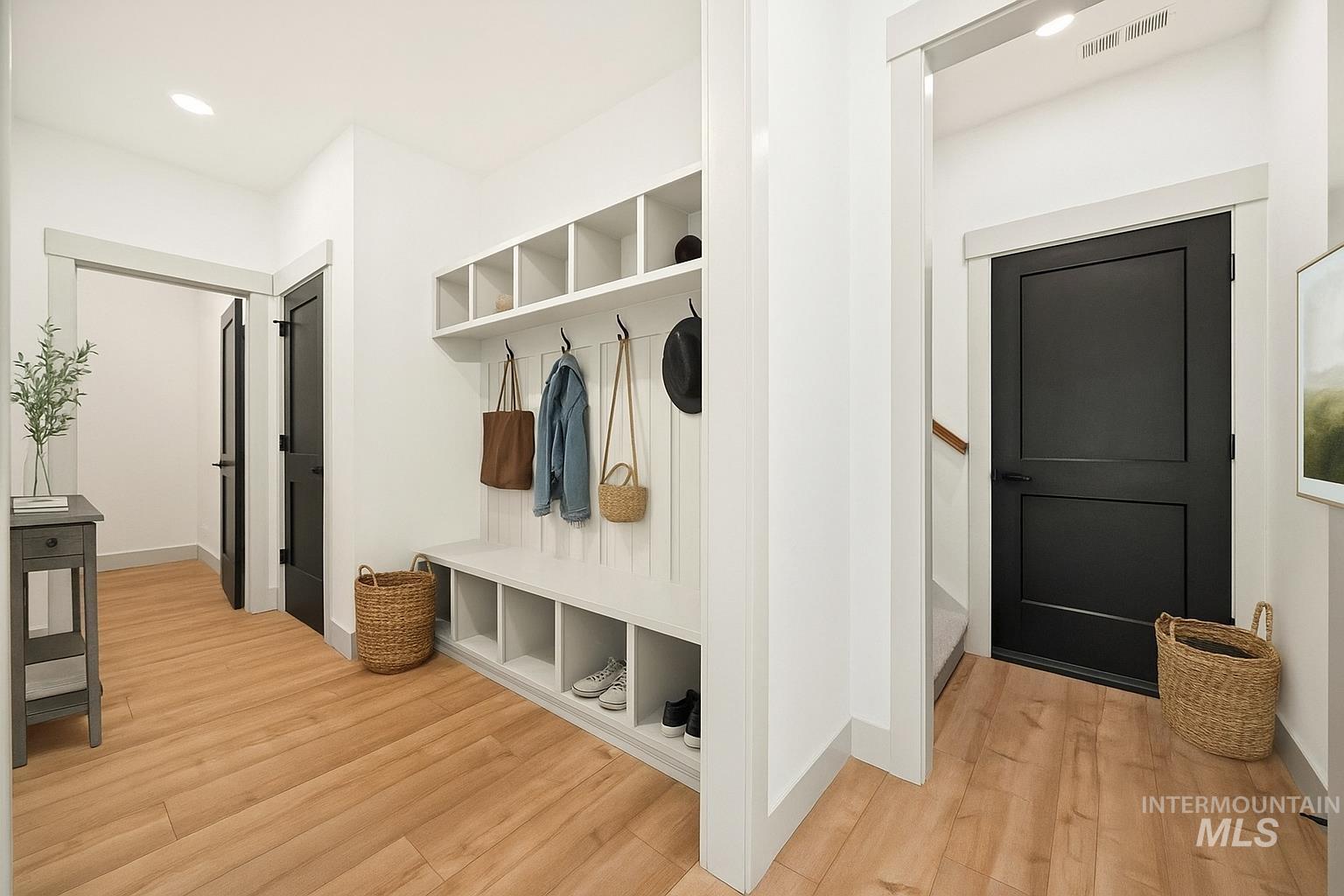 Mudroom with light wood-type flooring and baseboards