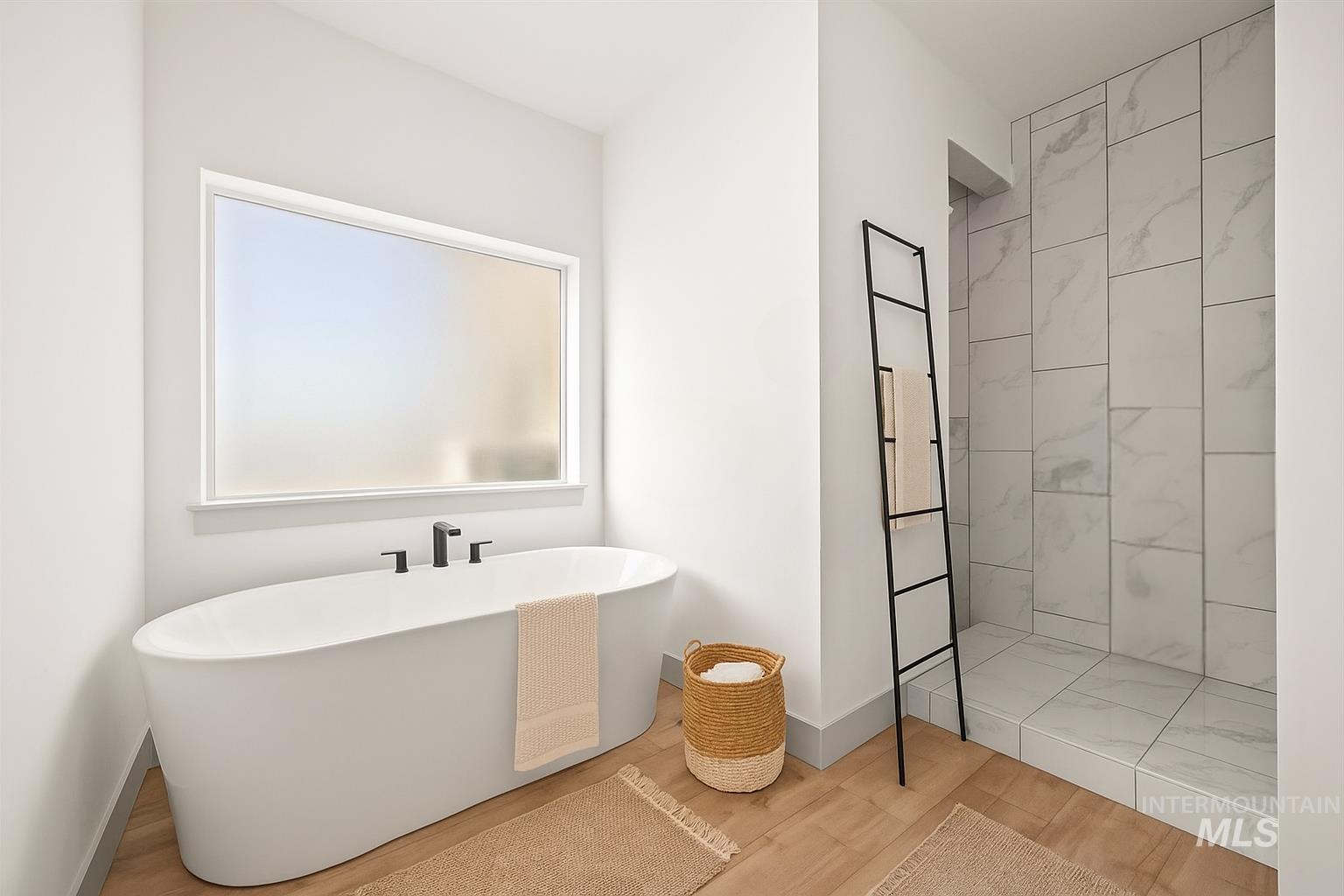 Bathroom with a soaking tub, a tile shower, and wood finished floors