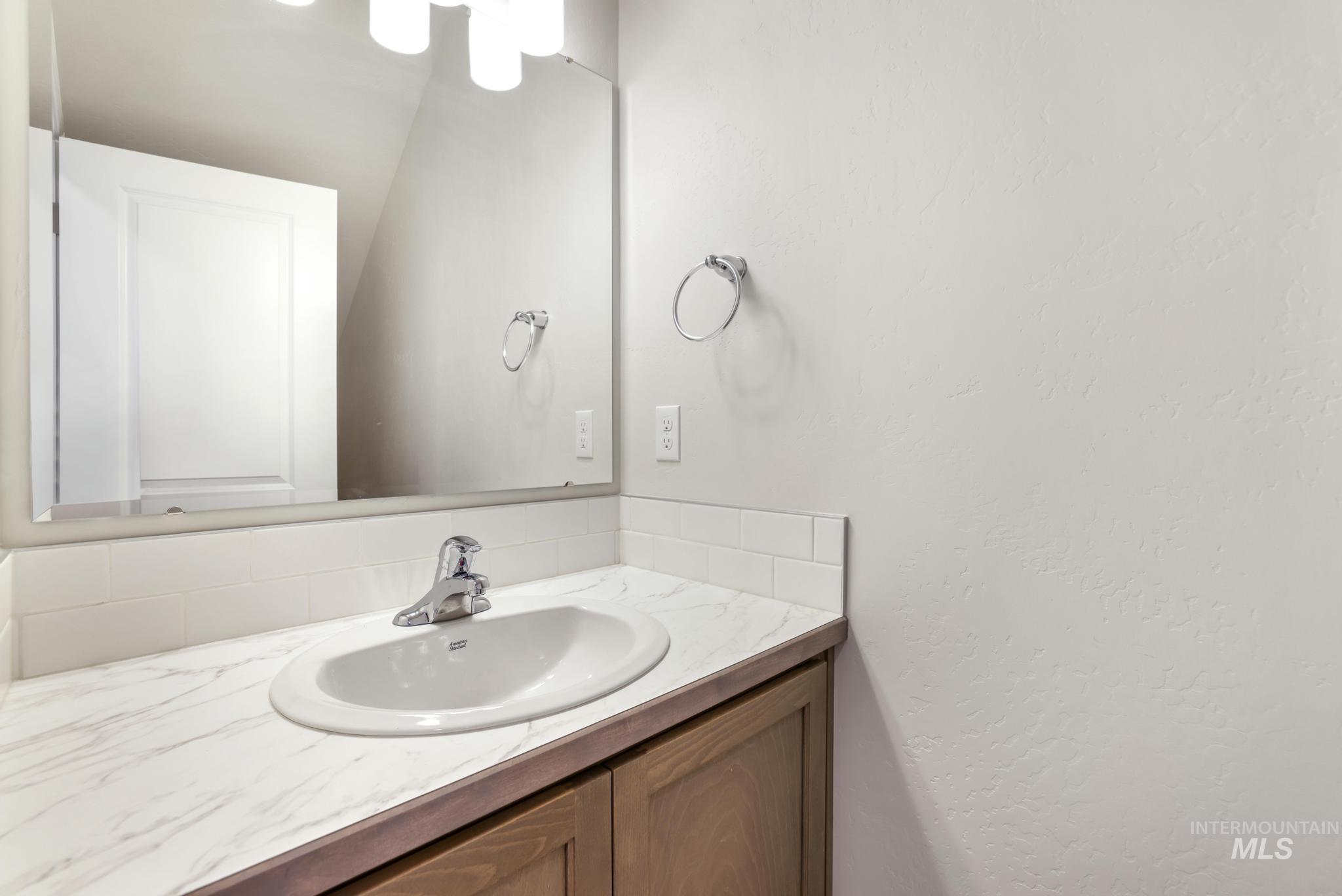 Bathroom featuring vanity and a textured wall