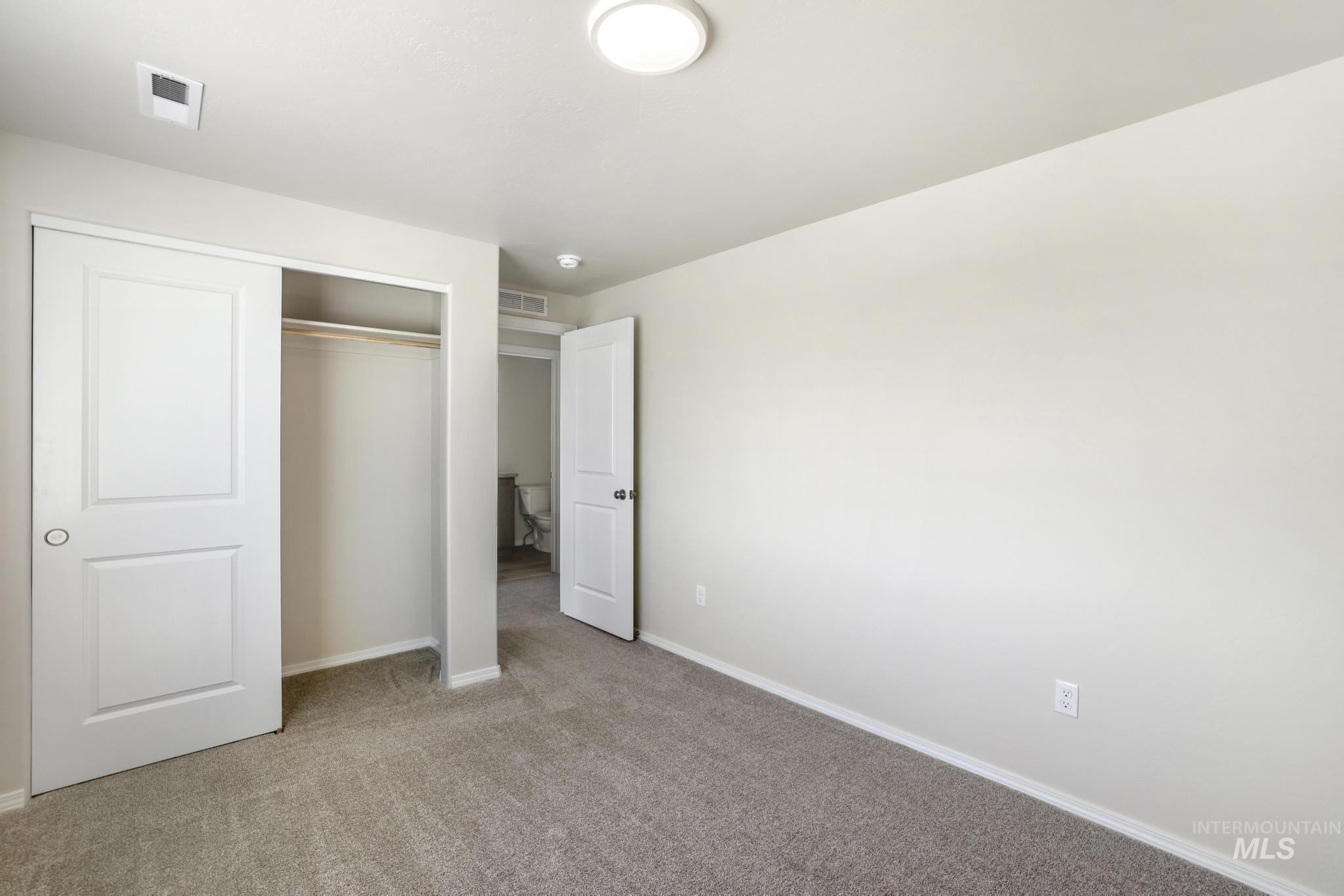 Unfurnished bedroom featuring carpet flooring and a closet