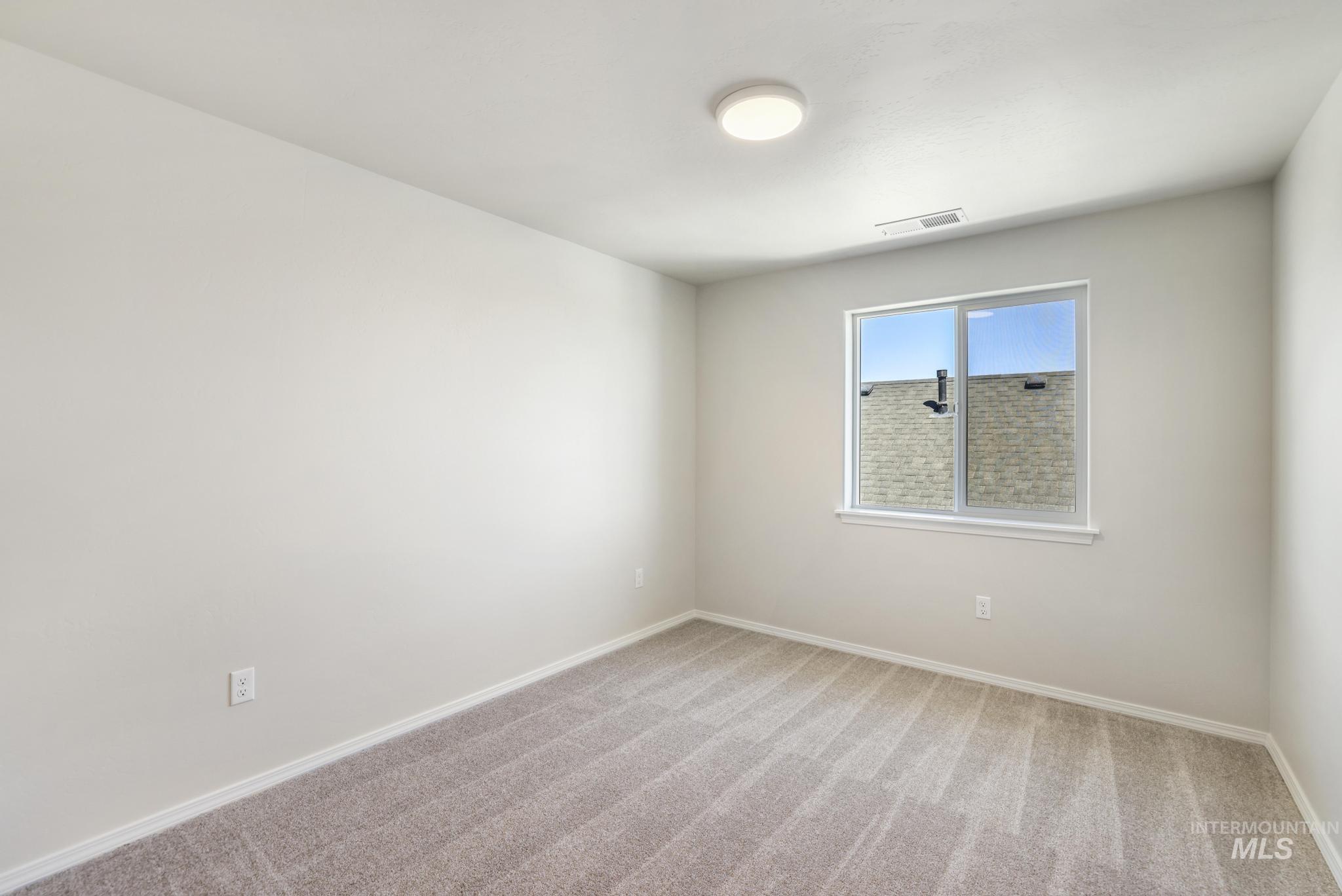 Carpeted empty room featuring baseboards