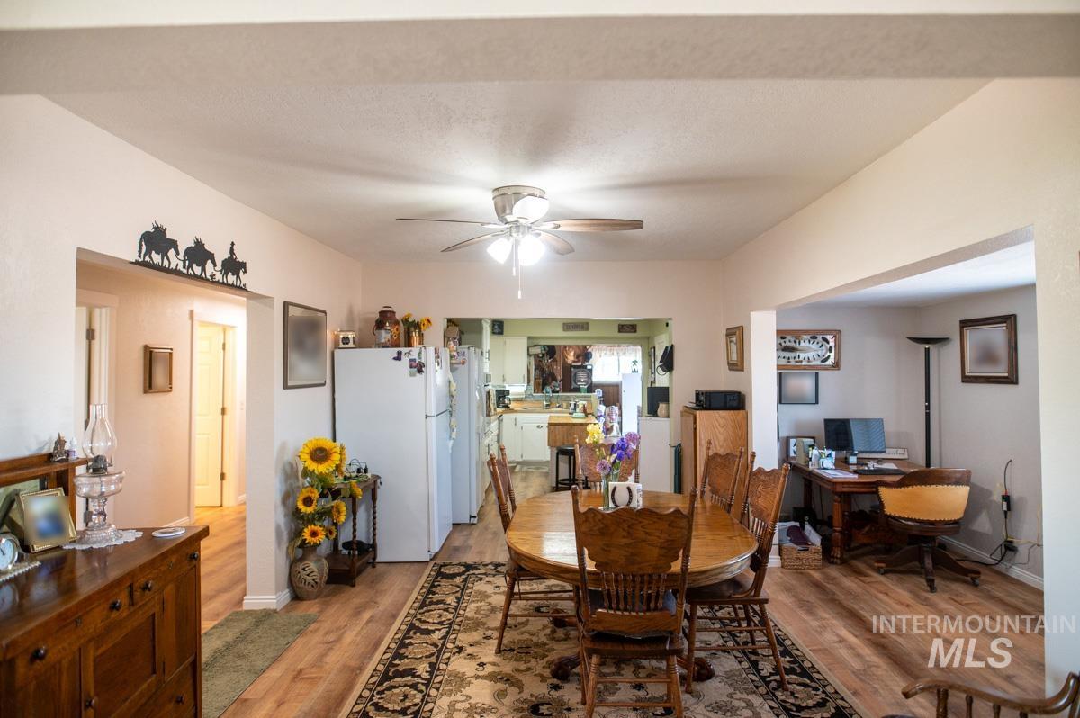 Dining room with ceiling fan, light wood-style floors, and an office area