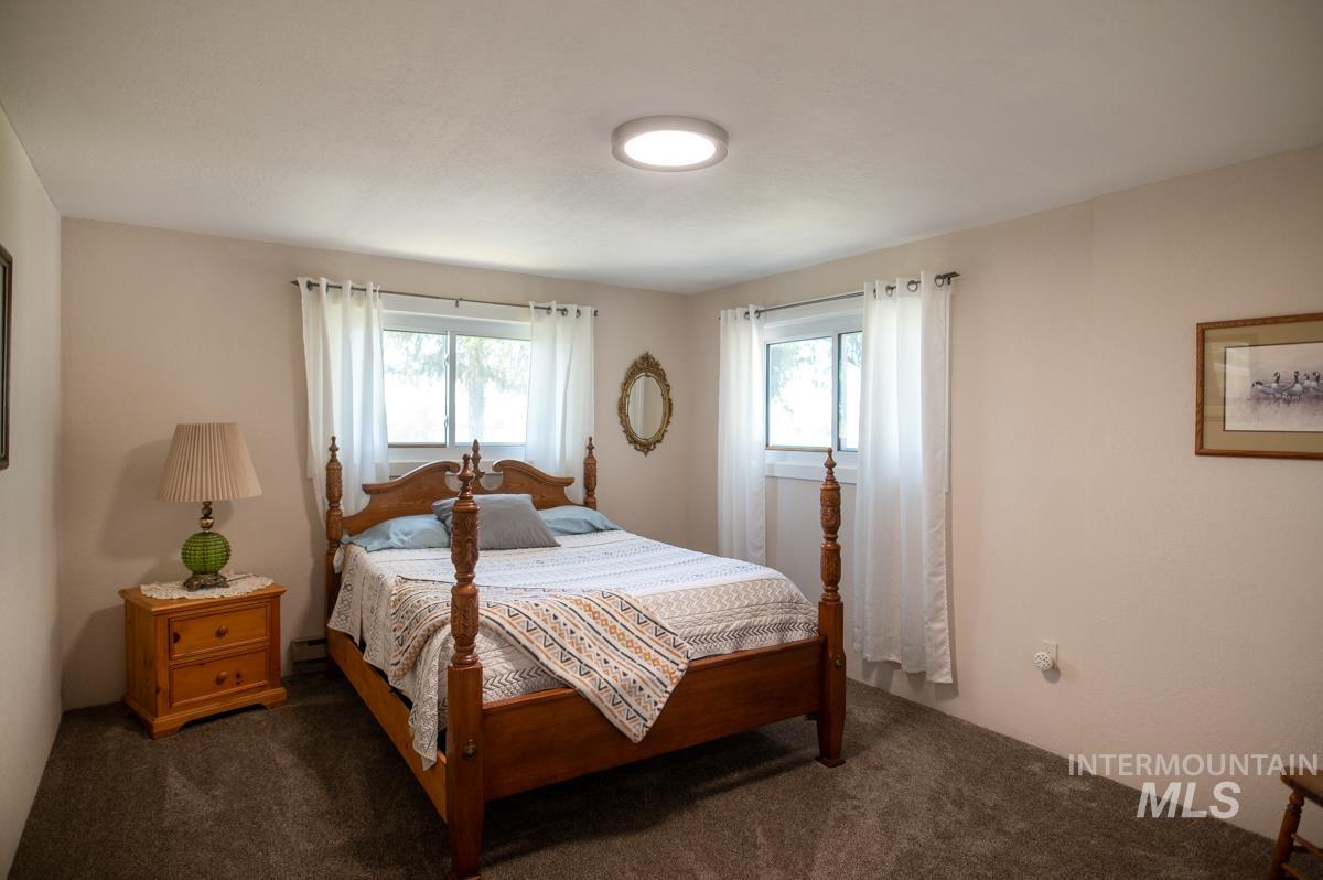Bedroom featuring dark colored carpet and a baseboard radiator