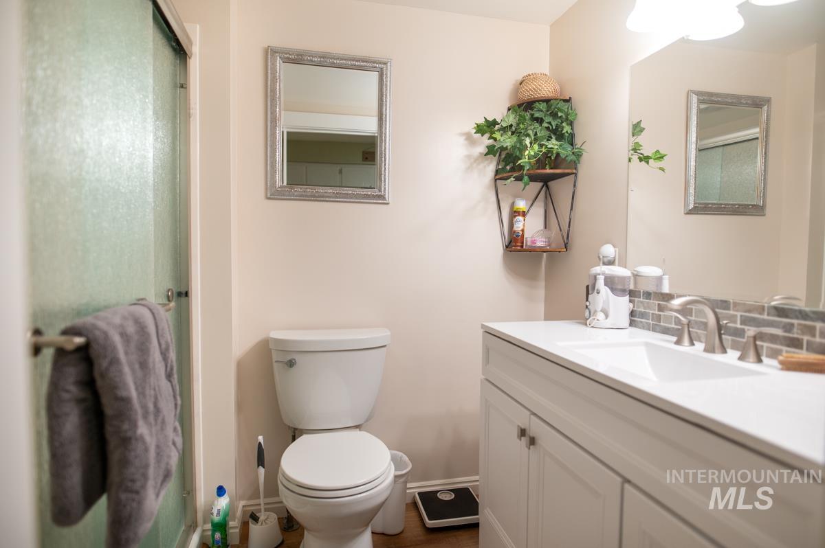 Full bathroom with a stall shower, vanity, and tasteful backsplash