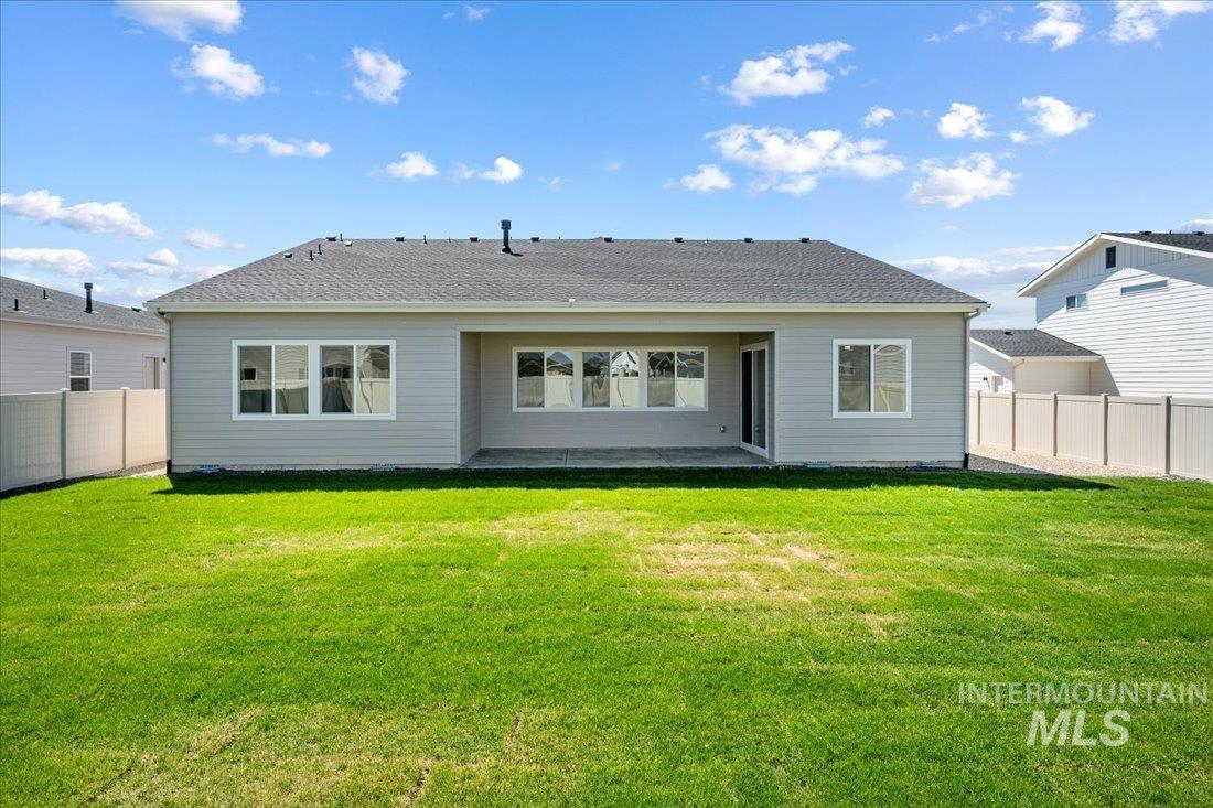 Rear view of property featuring a fenced backyard, a patio area, and roof with shingles