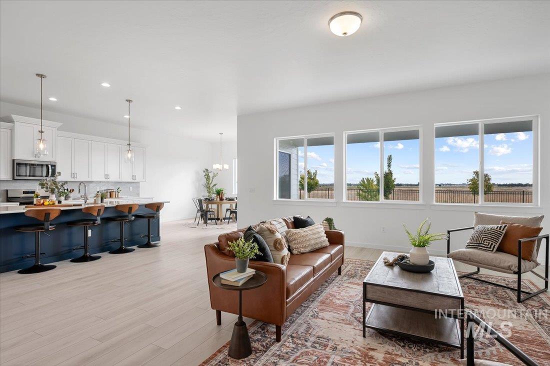 Living area with light wood finished floors and recessed lighting