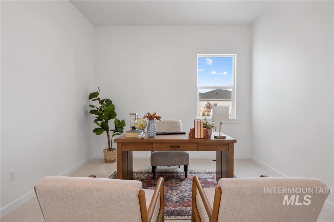 Office with baseboards and light colored carpet