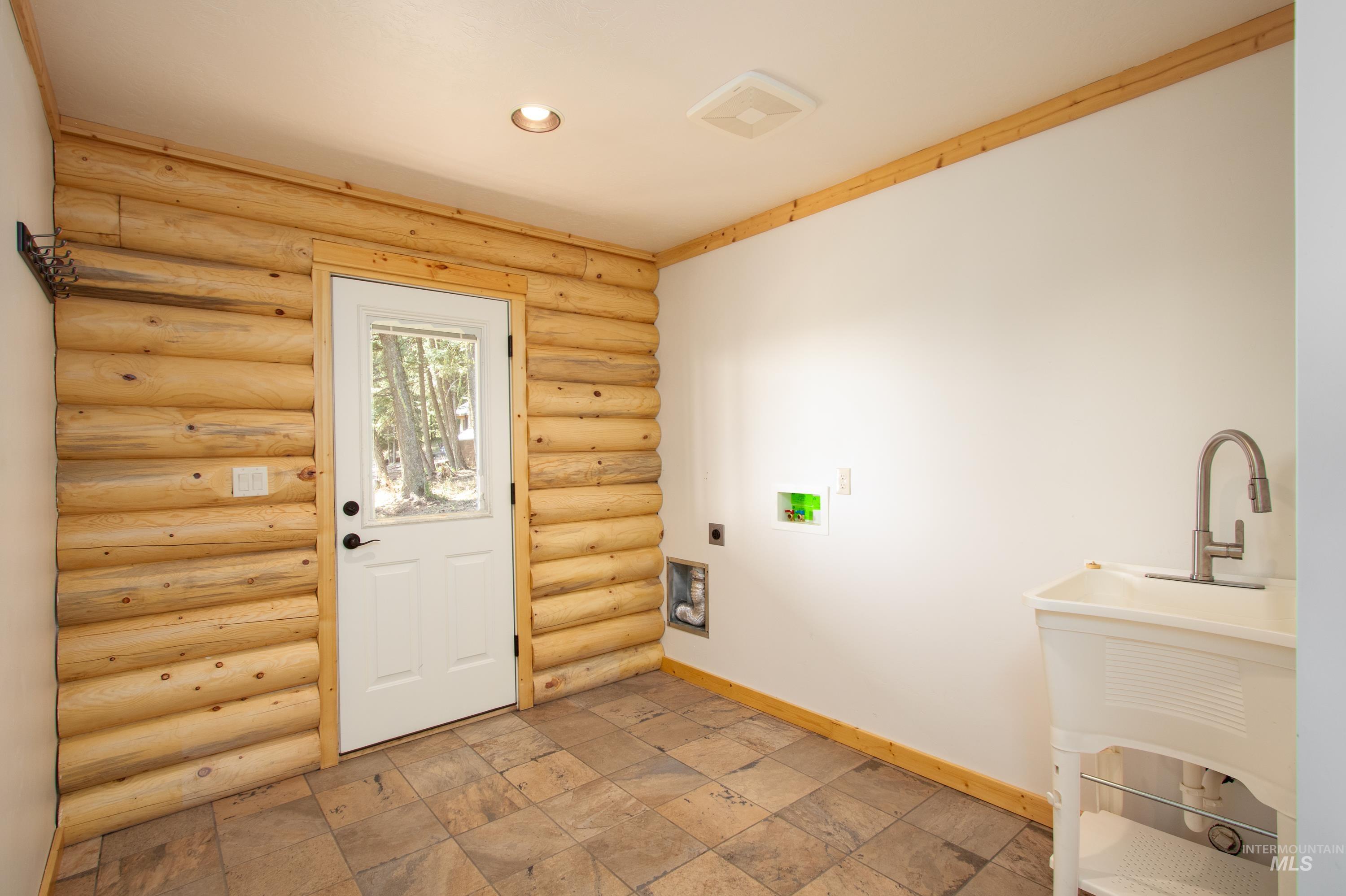 Laundry room featuring washer hookup, light stone finish flooring, rustic walls, hookup for an electric dryer, and recessed lighting