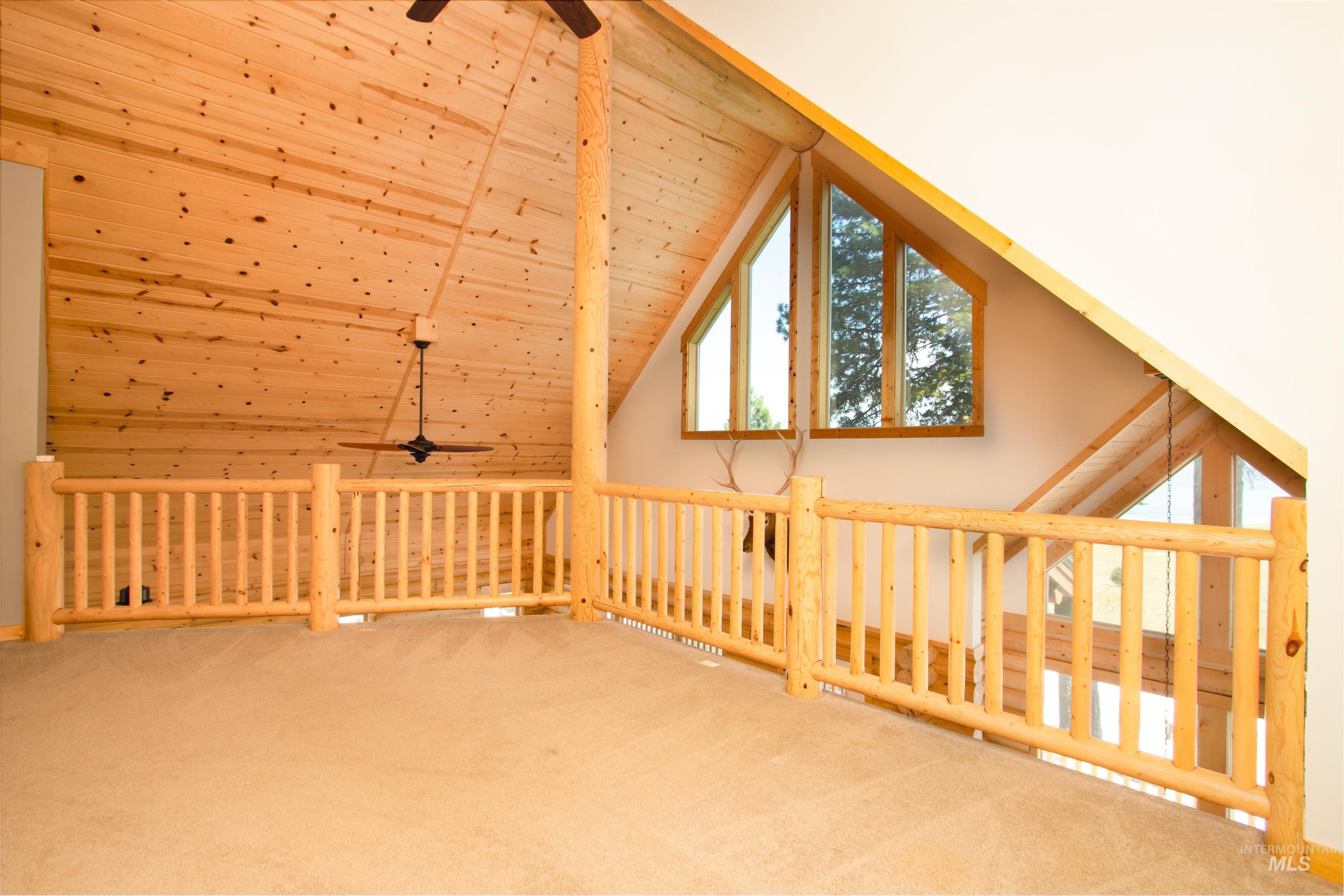 Additional living space with ceiling fan, carpet, and a vaulted wood ceiling