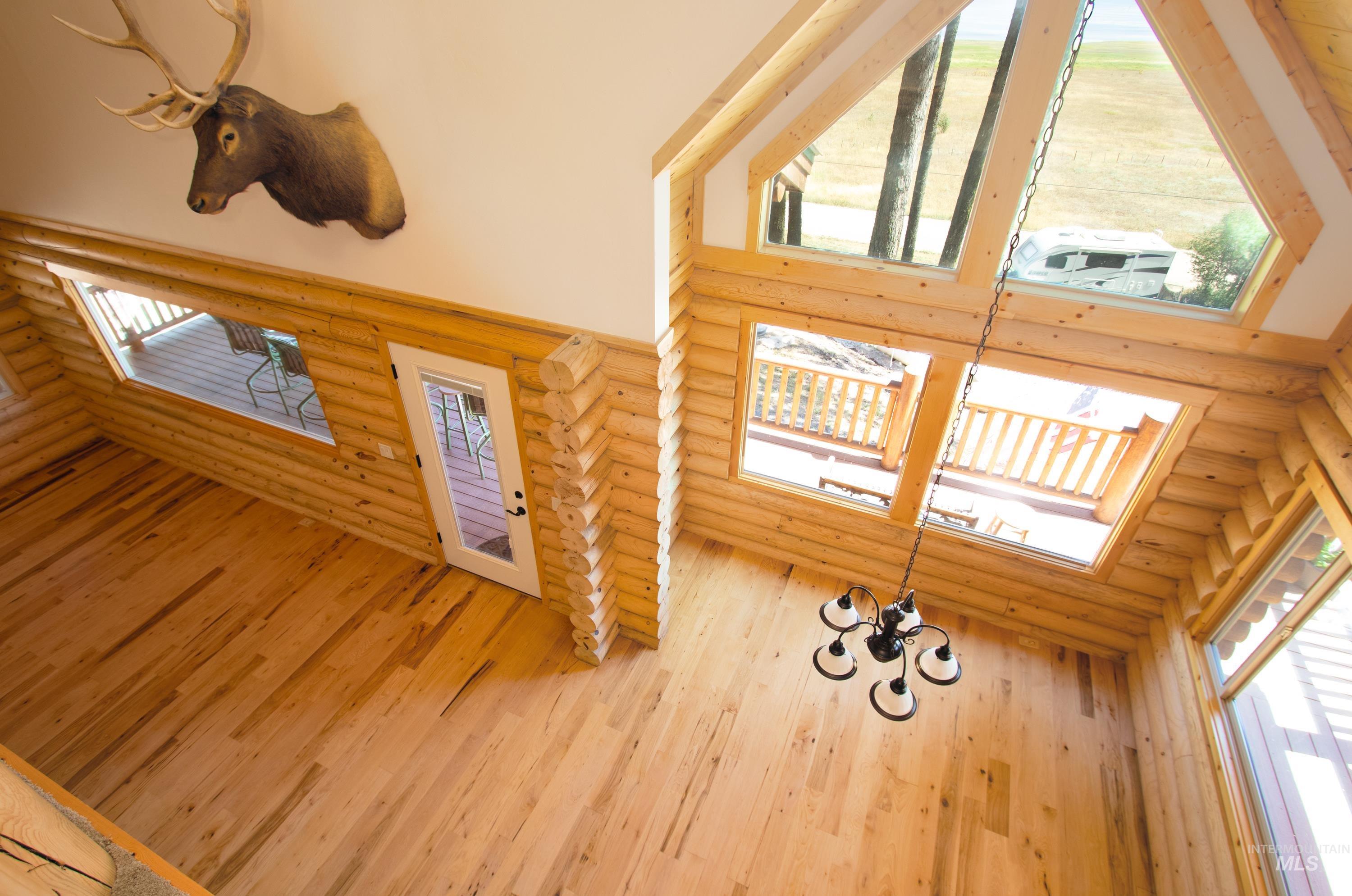 Foyer featuring rustic walls, a high ceiling, a skylight, and light wood finished floors