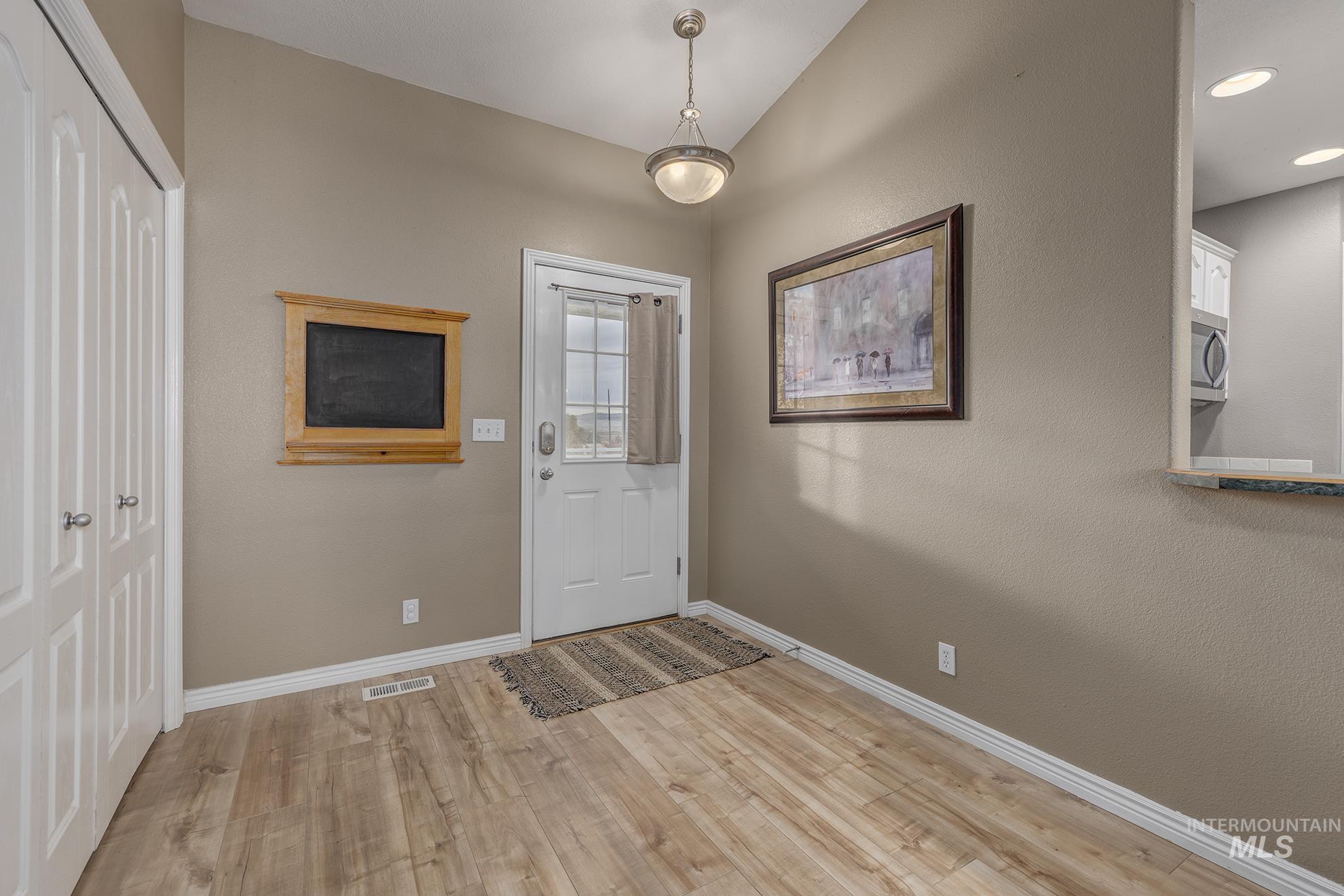 Entrance foyer featuring light wood-style flooring and lofted ceiling