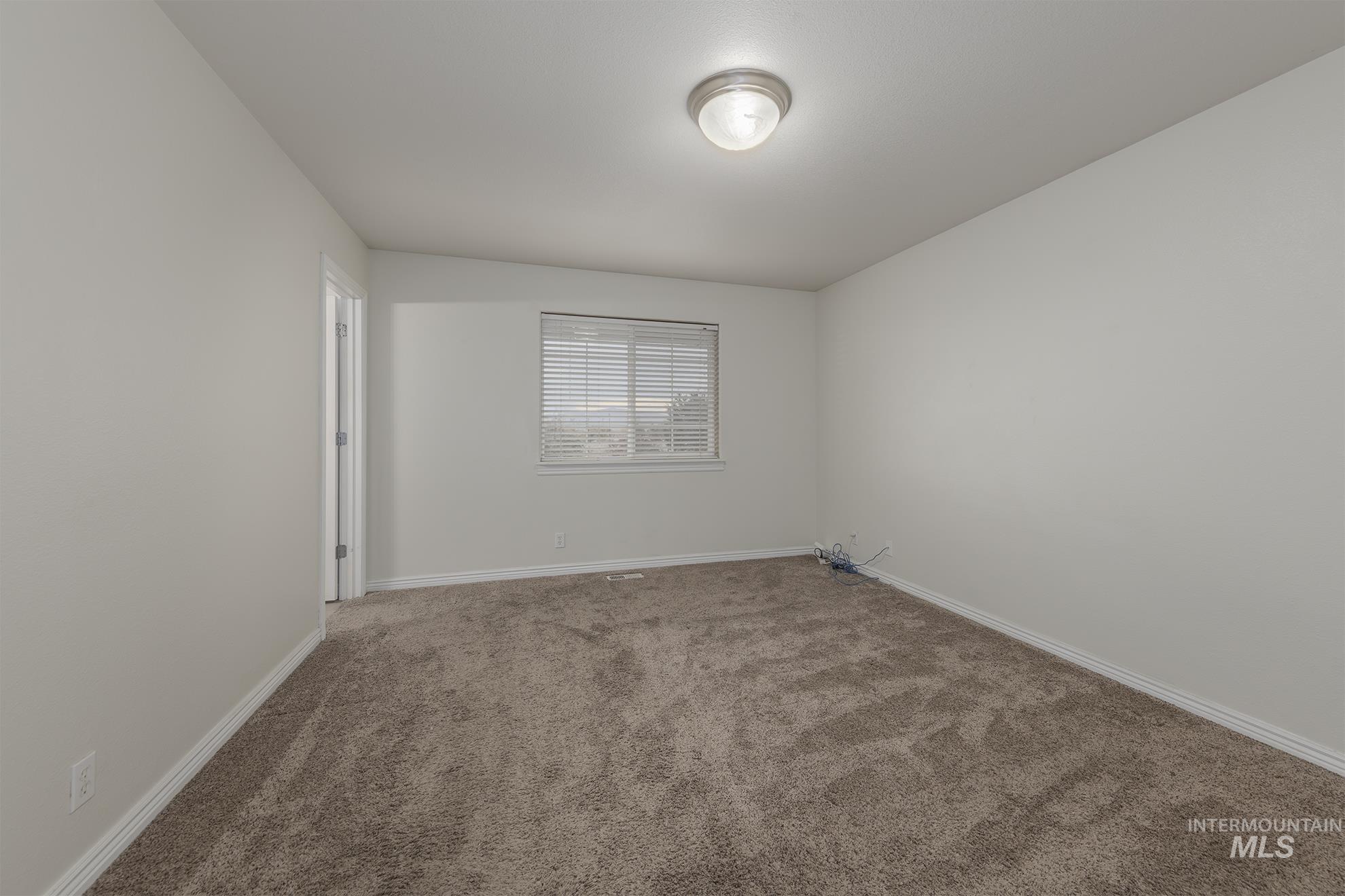 Carpeted empty room with baseboards
