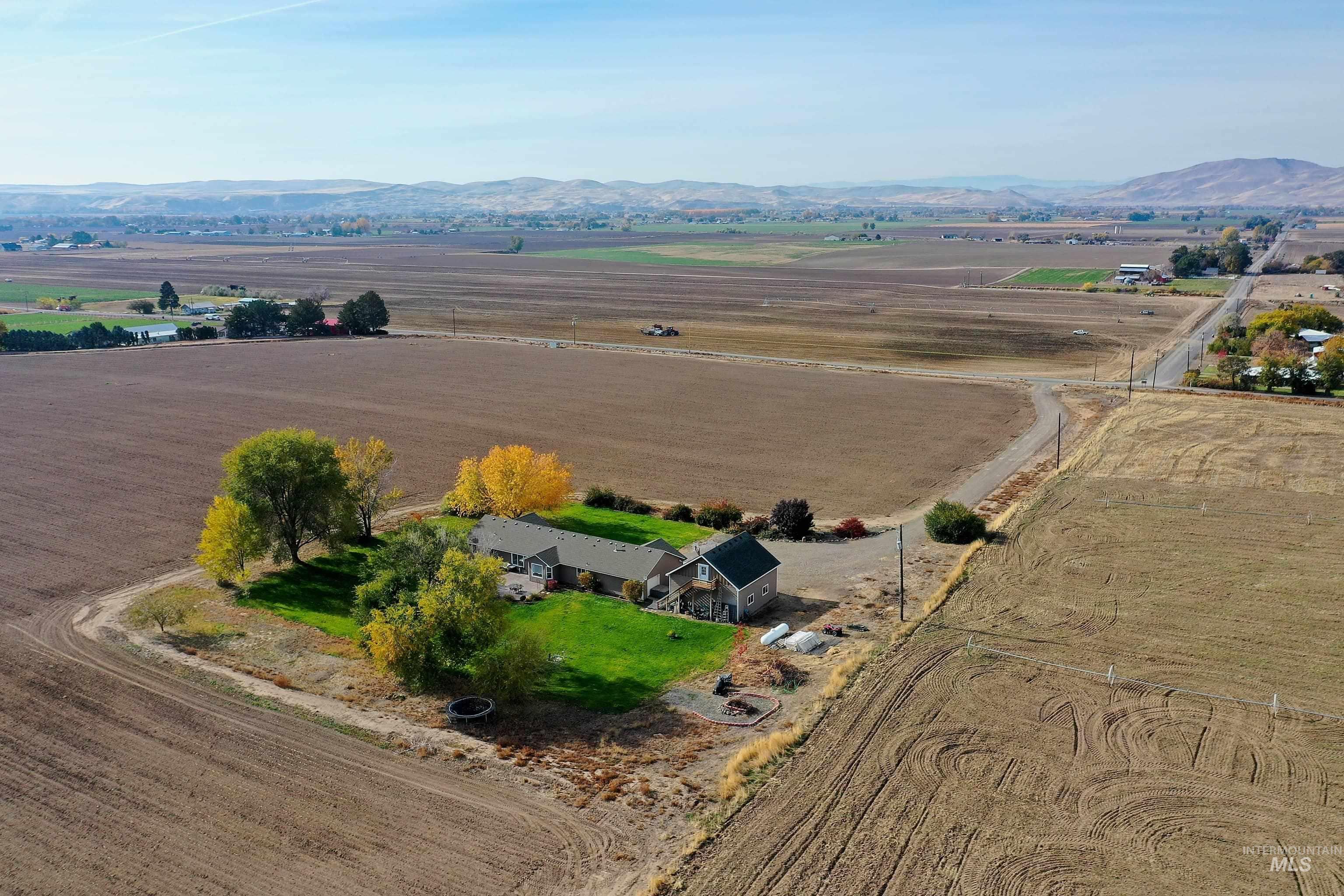 Aerial overview of property's location featuring rural landscape and a mountainous background