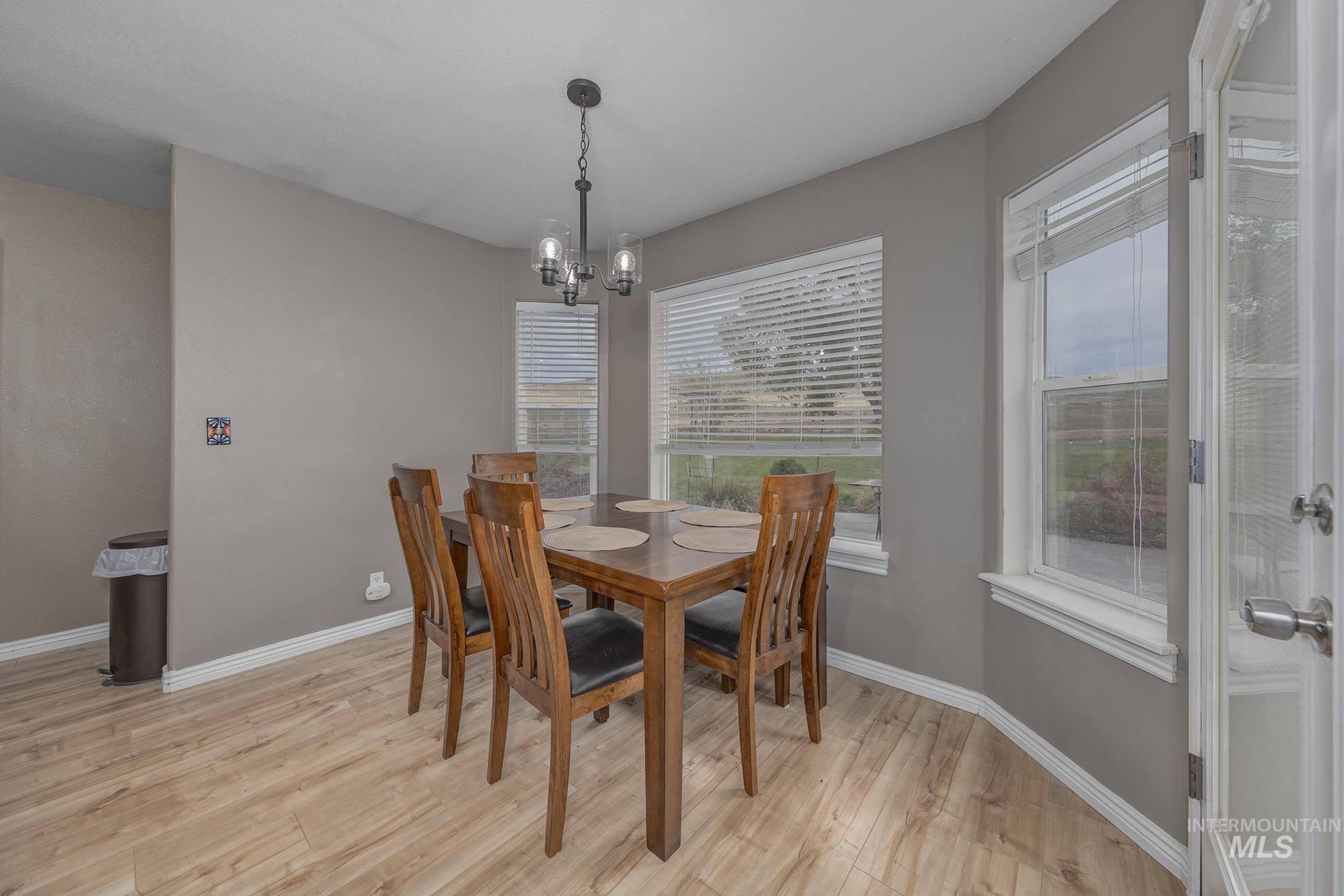 Dining room with light wood-style flooring and a chandelier