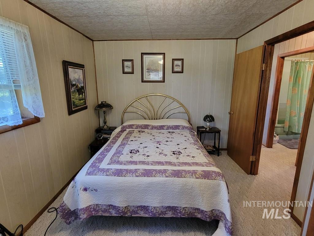 Bedroom featuring carpet flooring and wooden walls