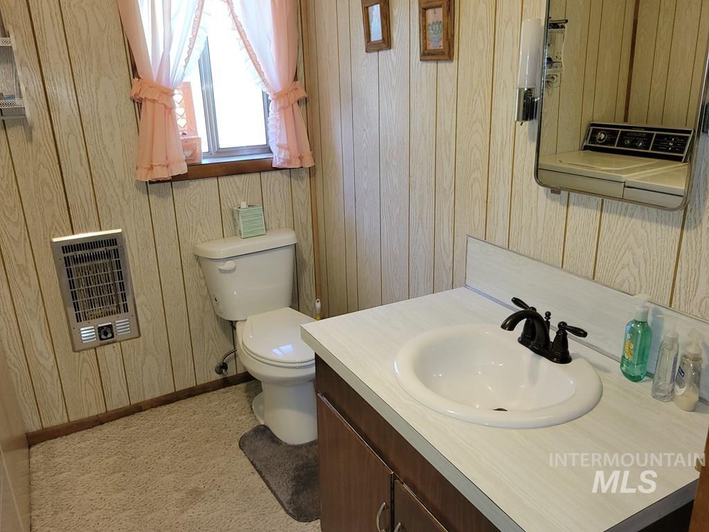 Bathroom with heating unit, vanity, and wooden walls