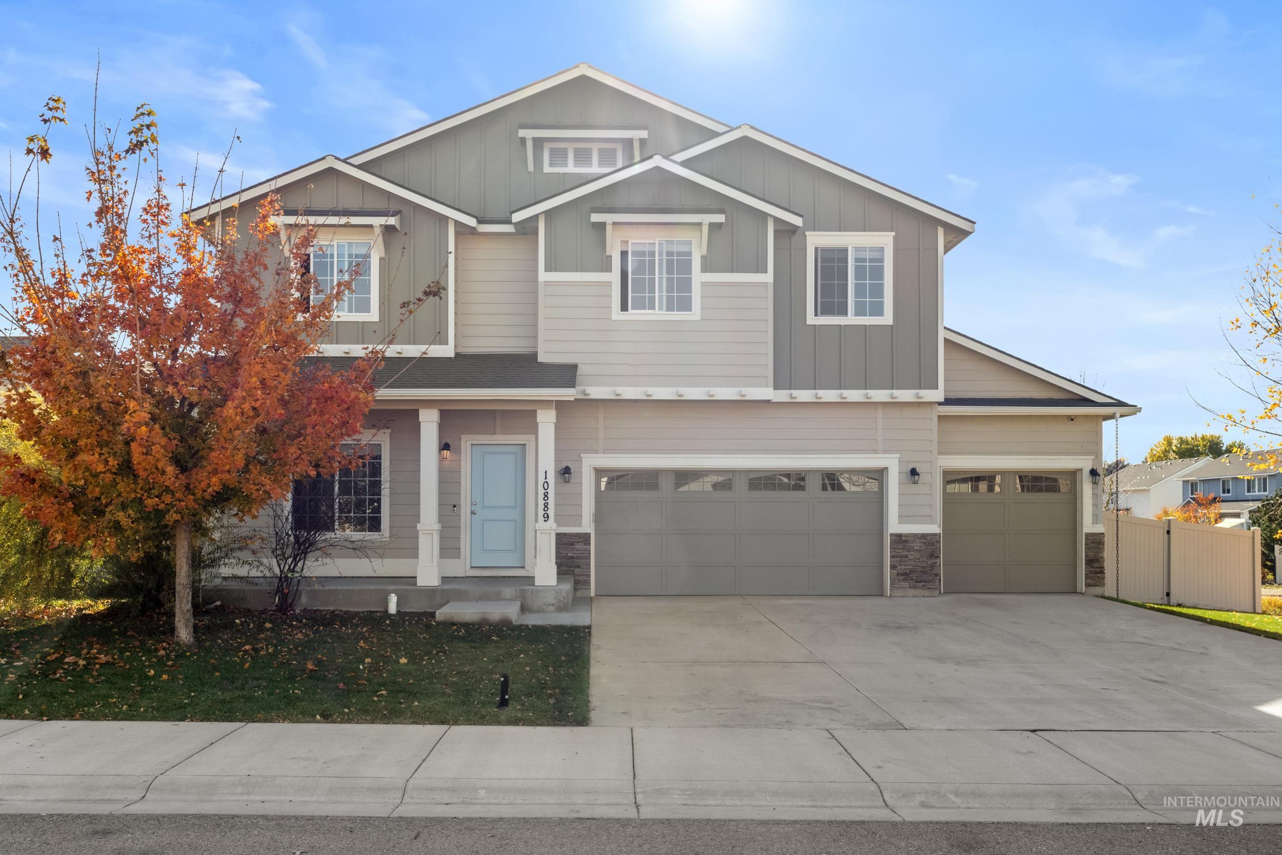 Craftsman house with driveway, board and batten siding, a garage, and stone siding