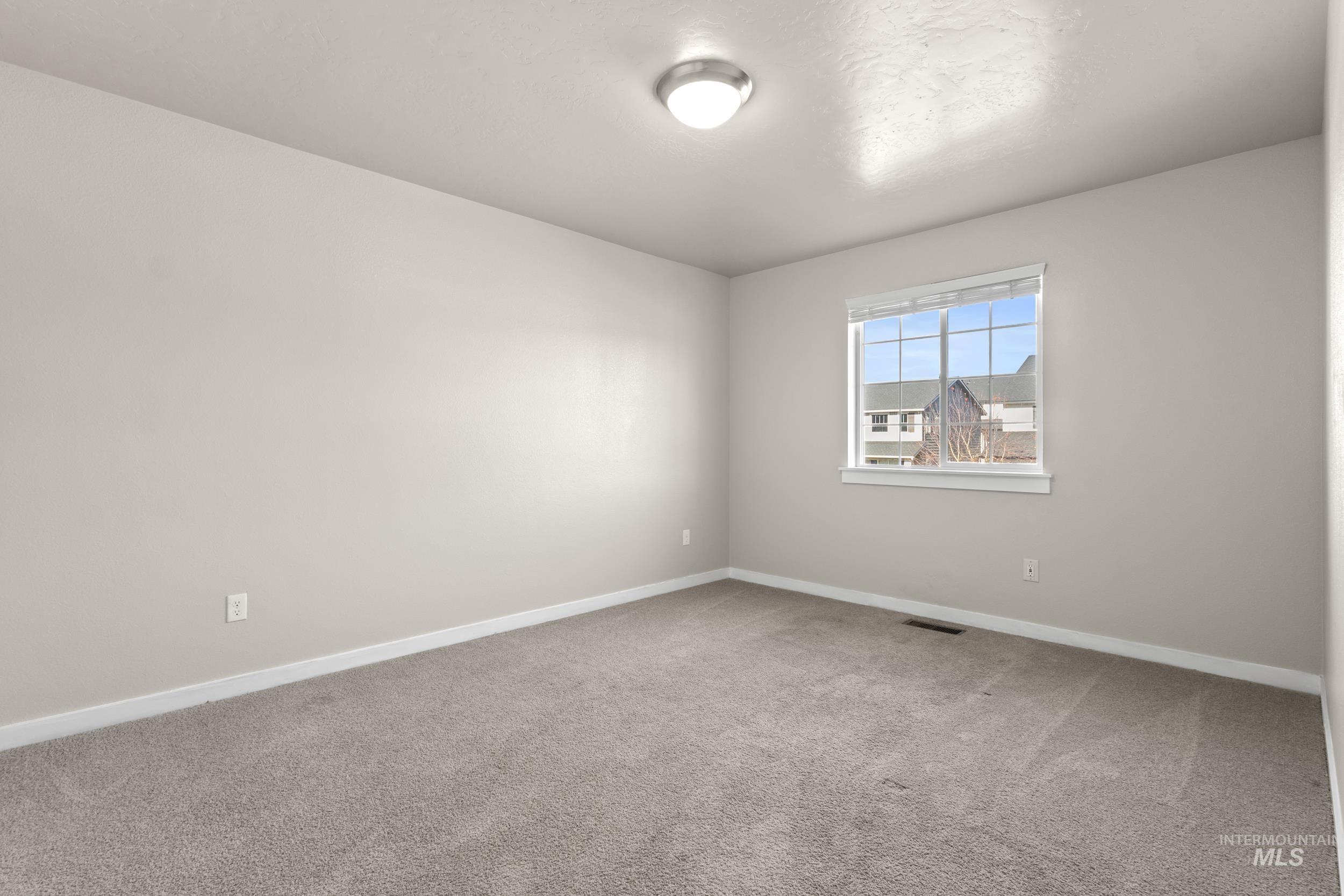 Spare room featuring baseboards and light carpet