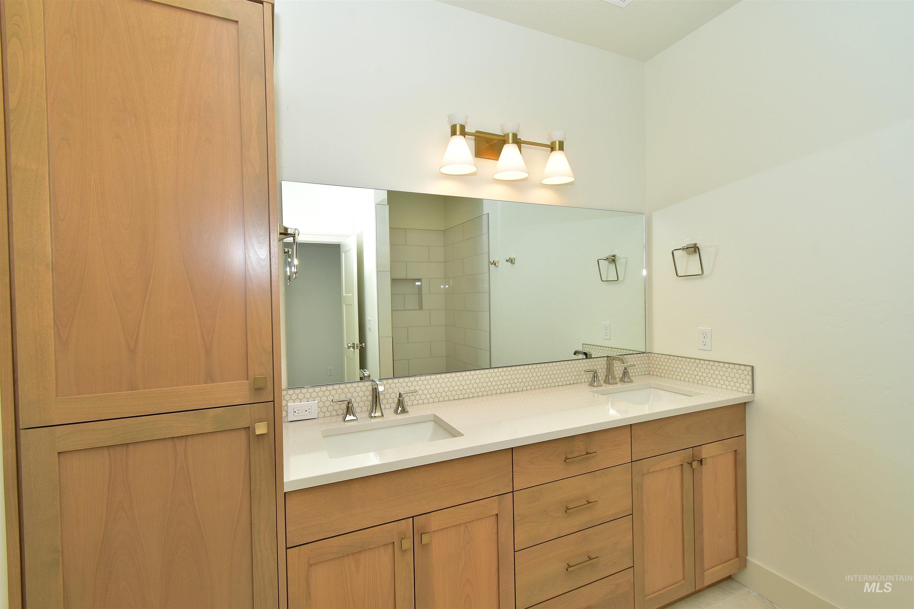 Full bath with double vanity and a stall shower
