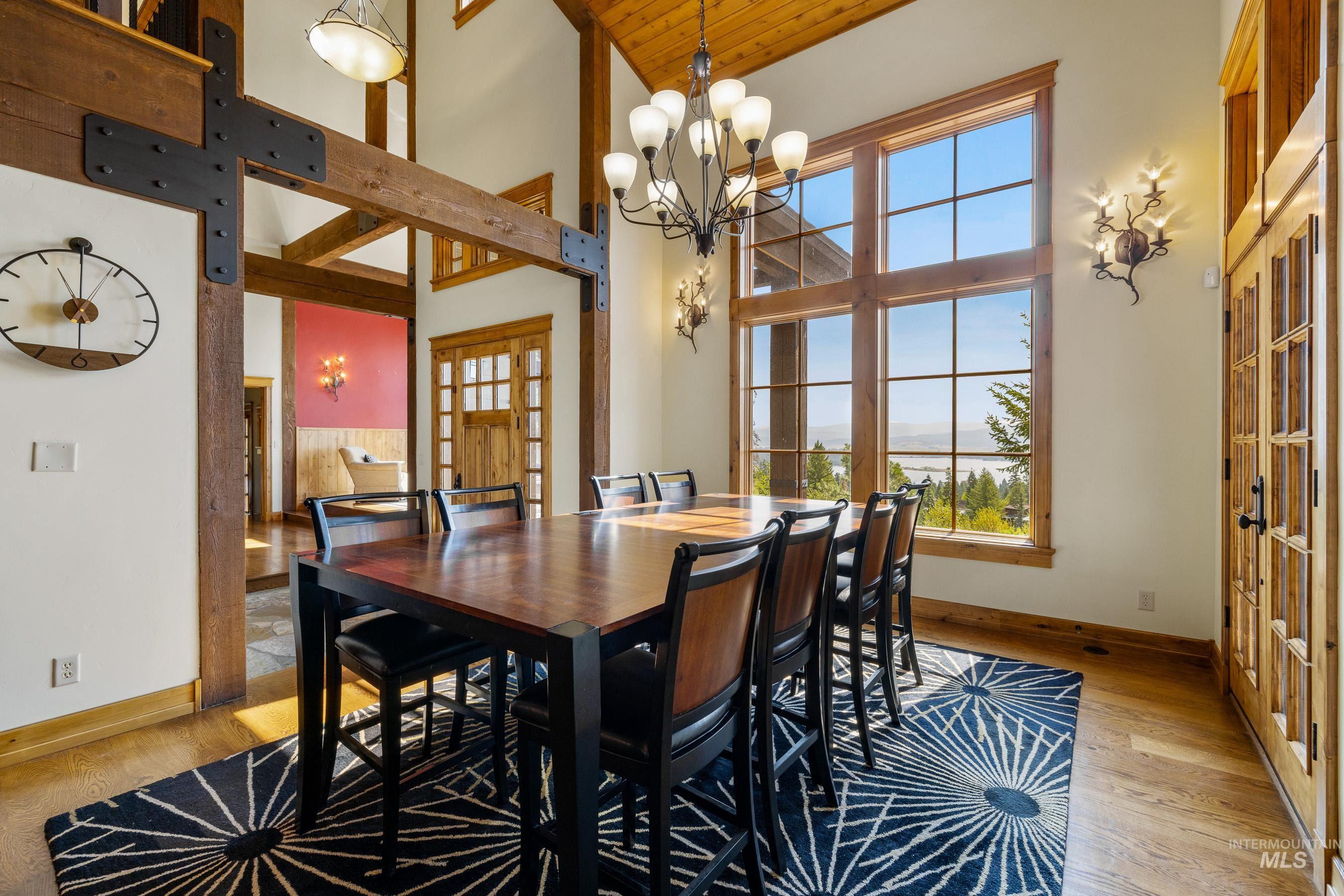 Dining space featuring a chandelier, light wood-style flooring, and high vaulted ceiling