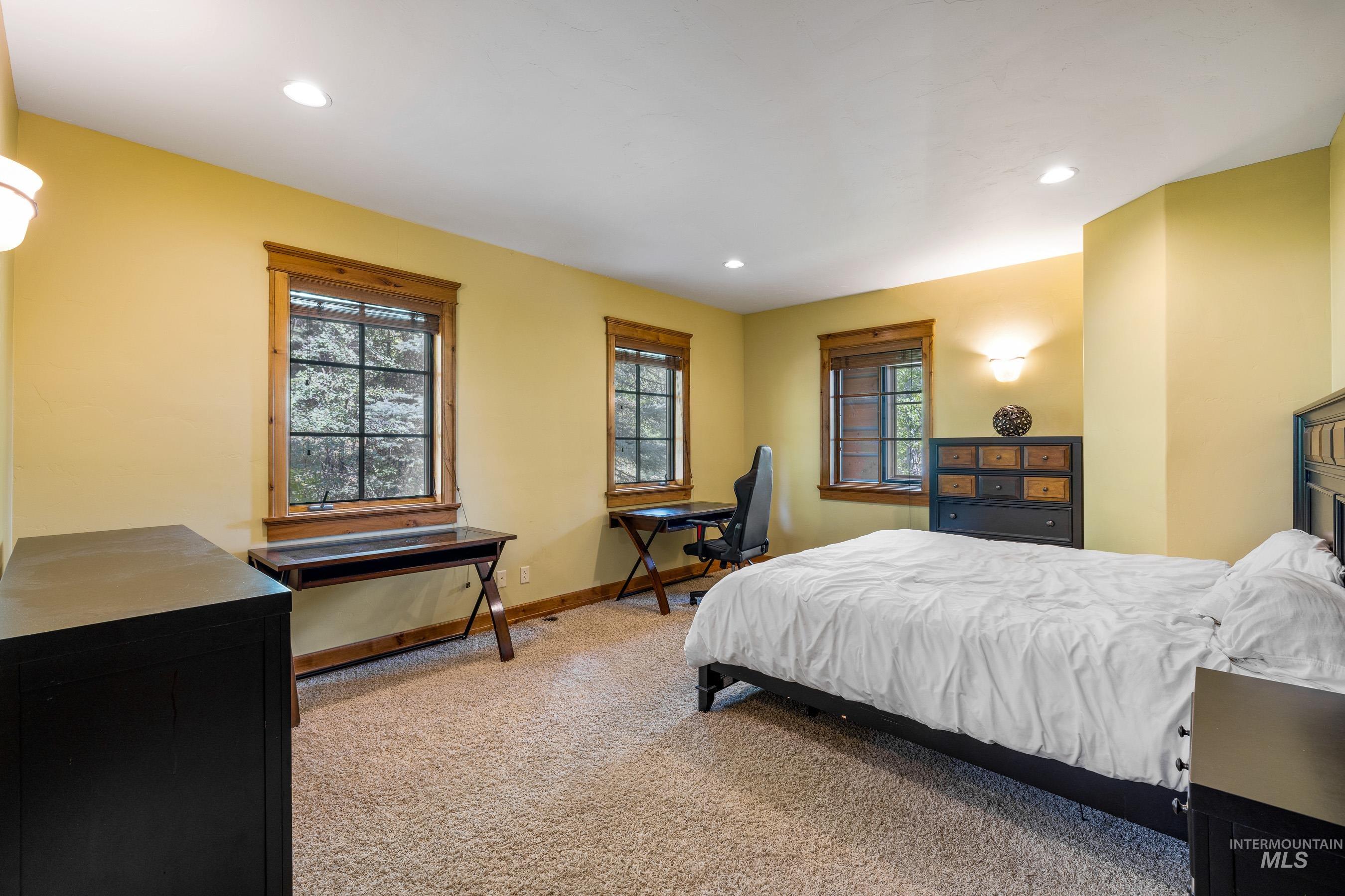 Bedroom featuring light colored carpet, recessed lighting, and an office area