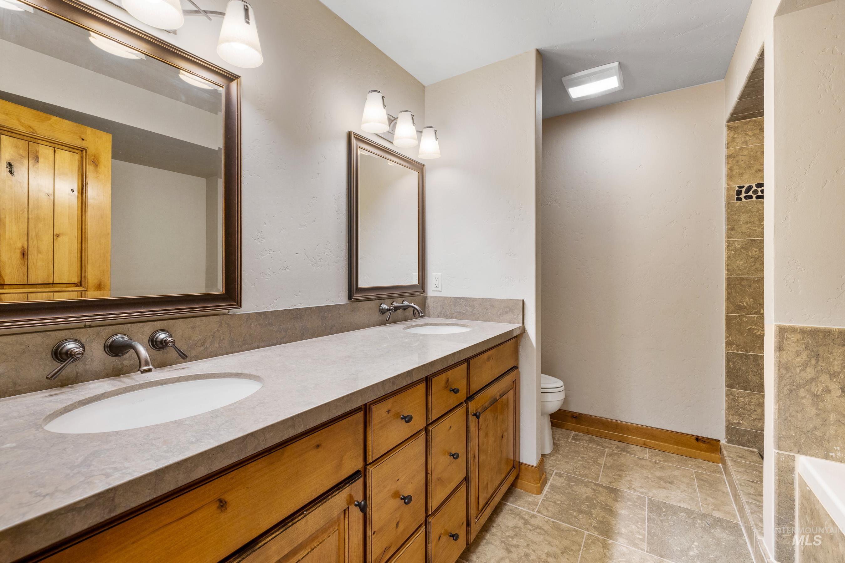 Bathroom featuring double vanity and tiled tub