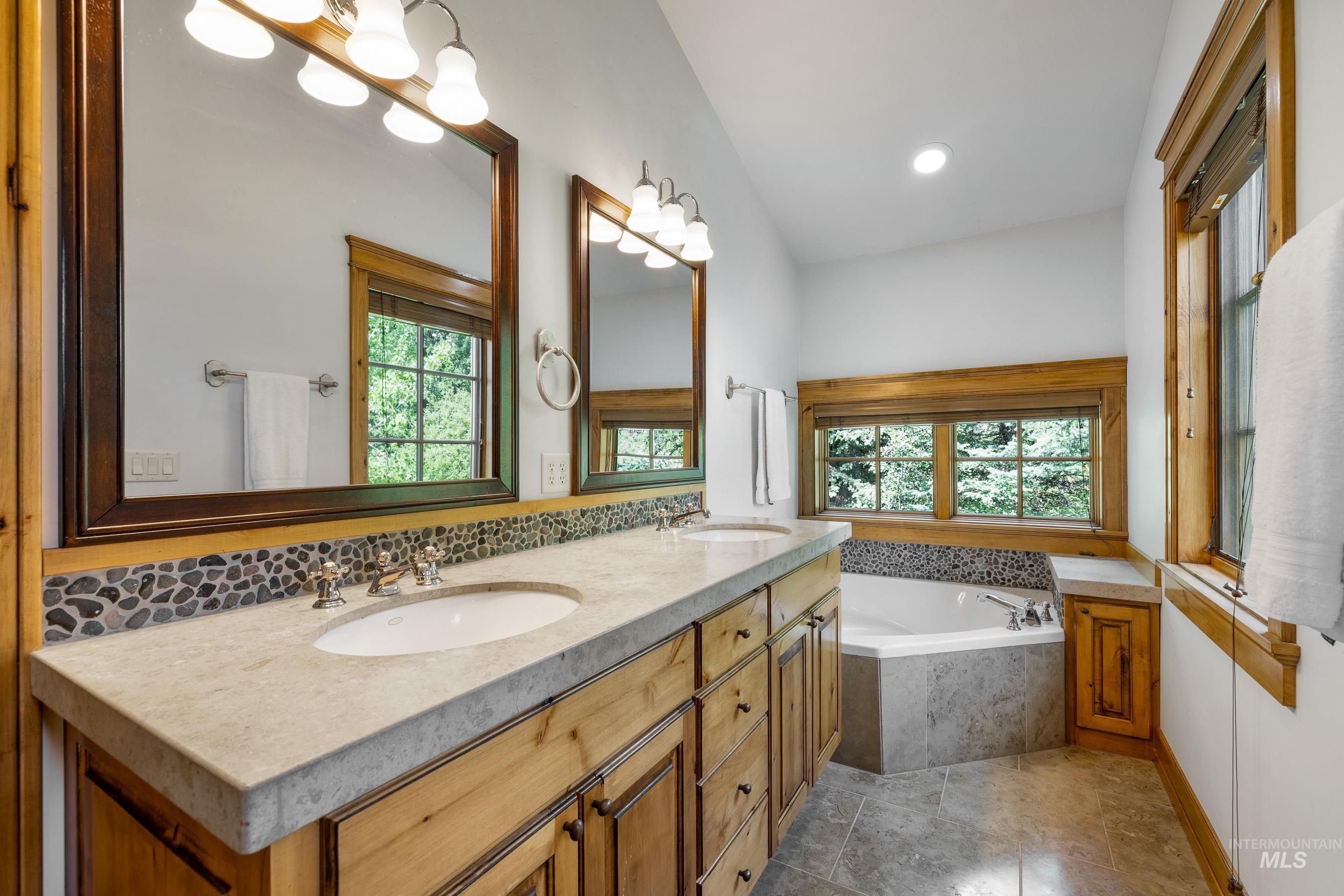 Full bathroom with double vanity, a bath, light tile patterned flooring, and recessed lighting