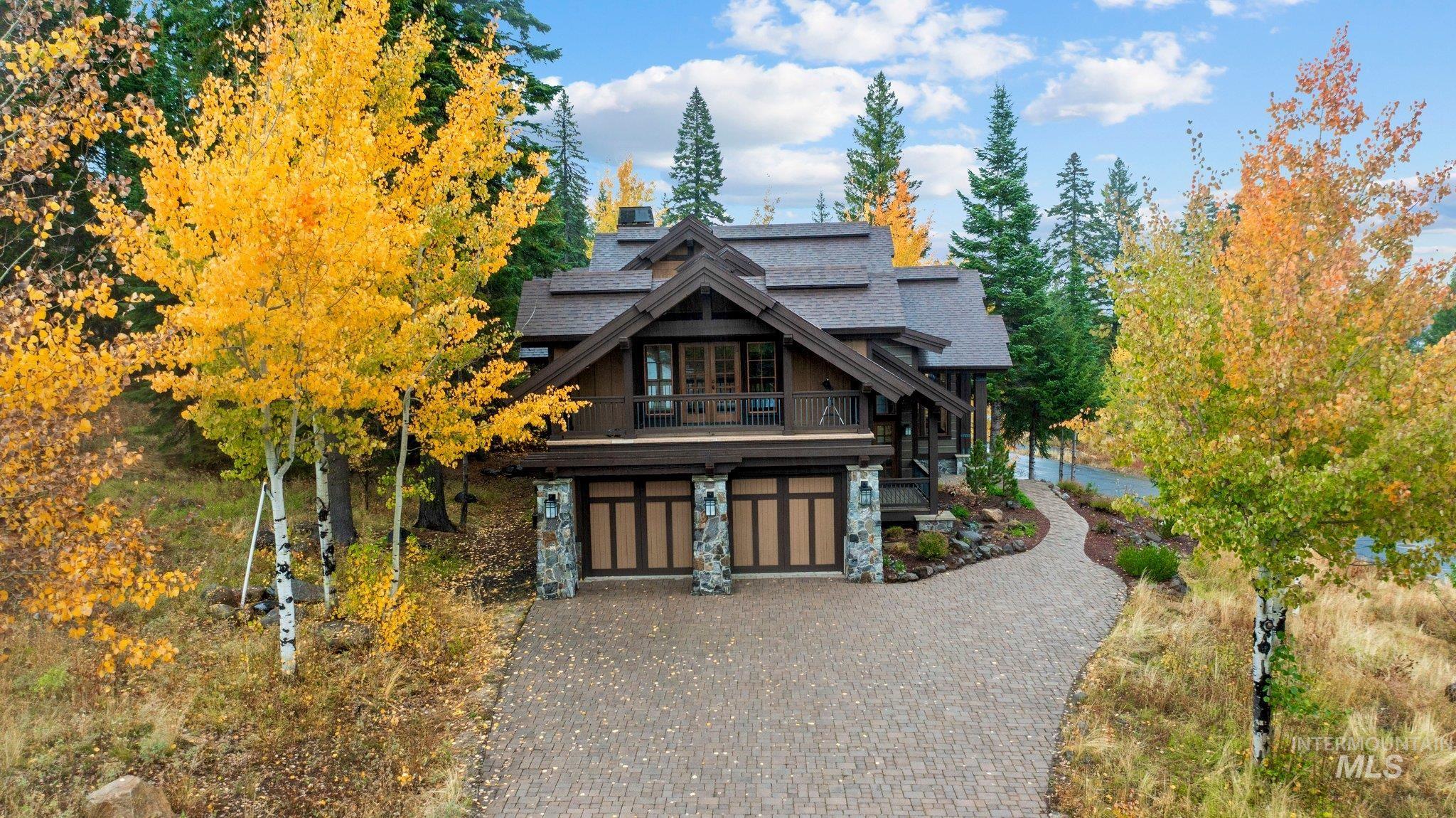 View of front of home with decorative driveway, an attached garage, and roof with shingles